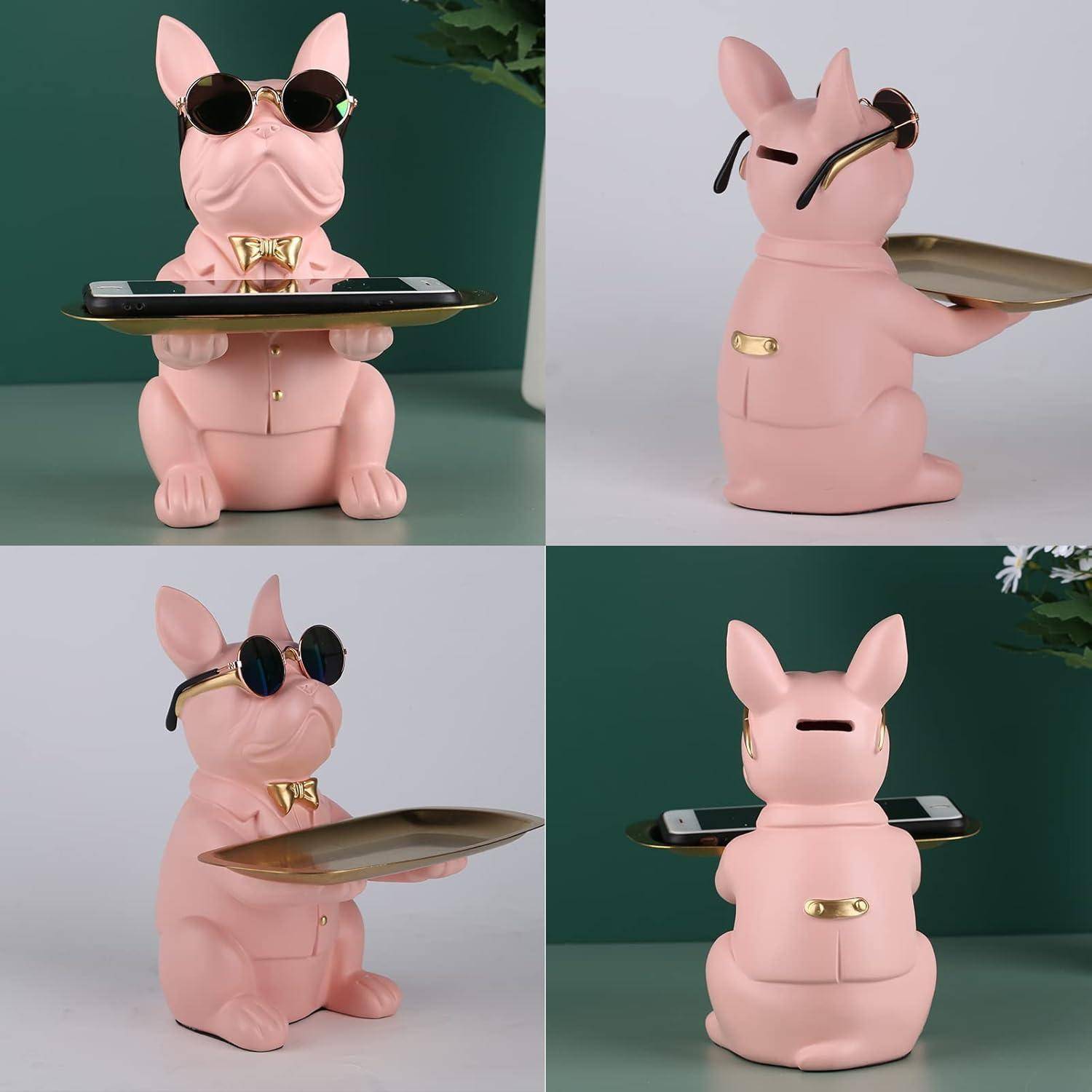 Eine dekorative Statue eines rosa Hundes, der eine Sonnenbrille und eine Fliege trägt und ein Tablett hält. Der Hund ist in einer verspielten Pose positioniert.
