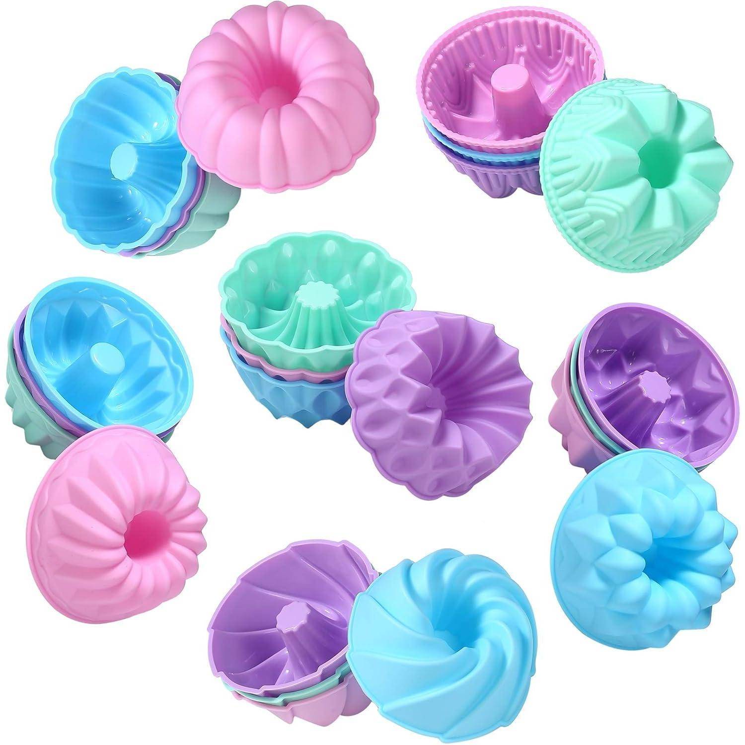 Bunte Silikonbackformen, die in Gruppen angeordnet sind und verschiedene geriffelte und gewellte Designs in pastellfarbenen Tönen von Blau, Rosa, Lila und Grün zeigen.