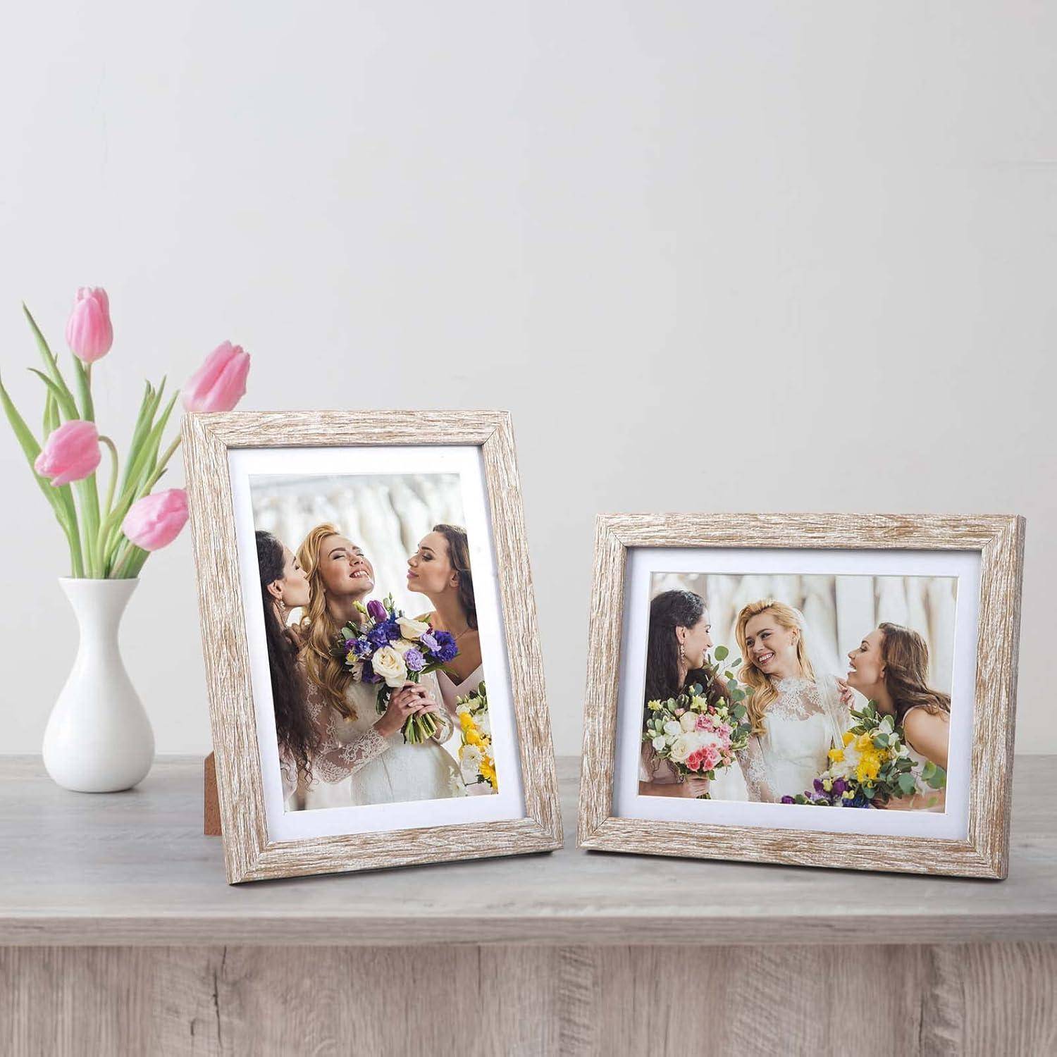 Zwei gerahmte Fotos auf einem Tisch, die jeweils eine fröhliche Braut mit Brautjungfern zeigen, die Blumensträuße halten. Eine Vase mit rosa Tulpen steht neben den Rahmen.