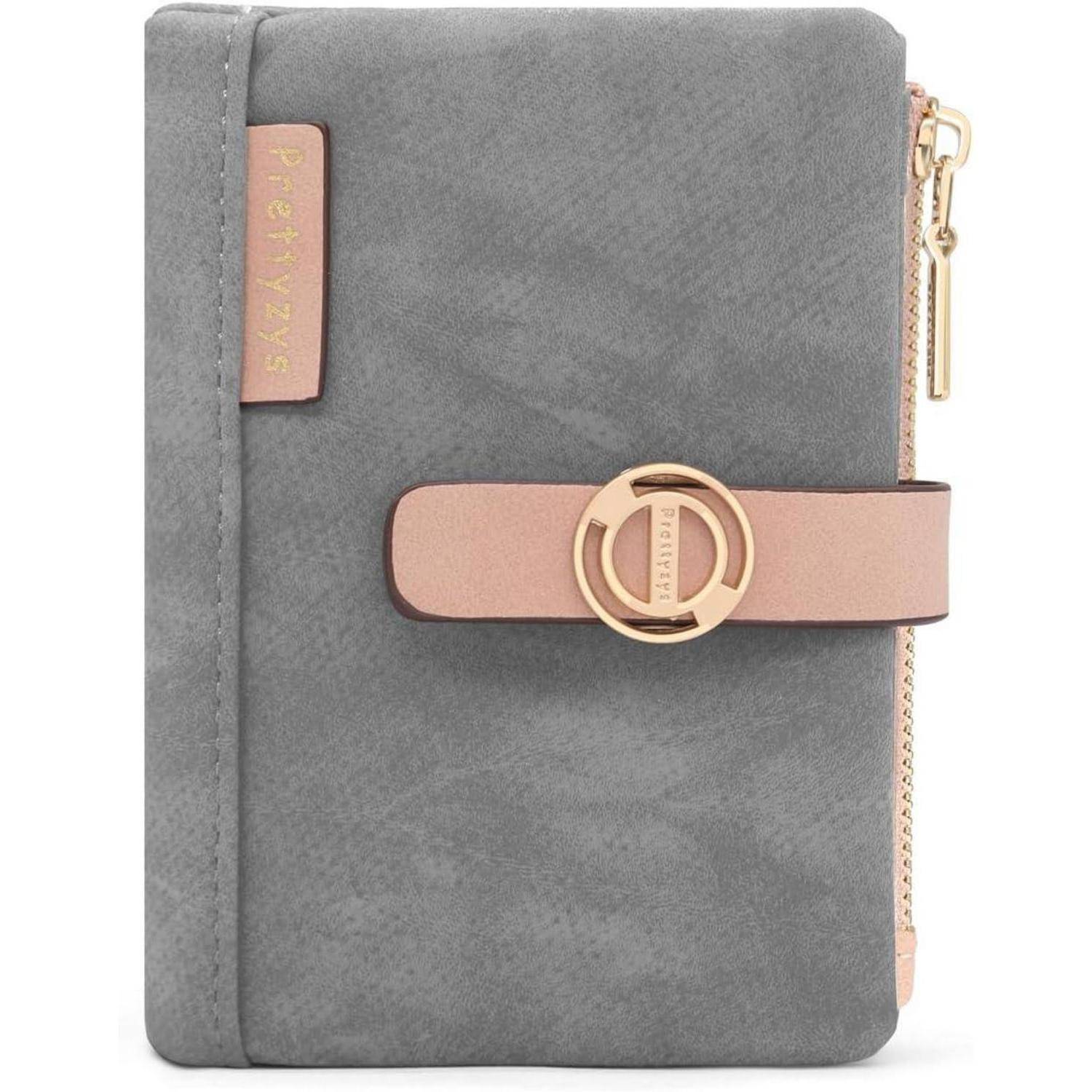 Eine graue Wildleder-Brieftasche mit einem rosa Lederriemen und goldener Schließe, beschriftet mit 'Prettyzys', mit einer goldenen Reißverschlusstasche an der Seite.