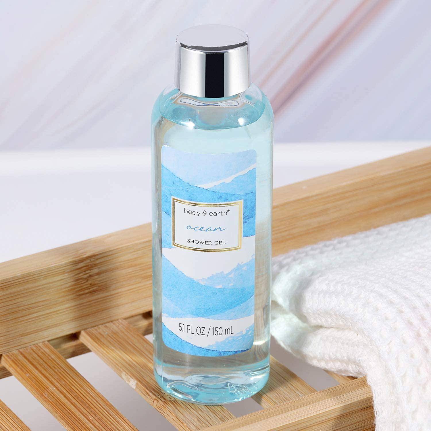Eine Flasche Duschgel 'Ocean' von body & earth, 150 ml, auf einem Holz-Badablage mit einem gefalteten weißen Handtuch, vor einem hellen Hintergrund.