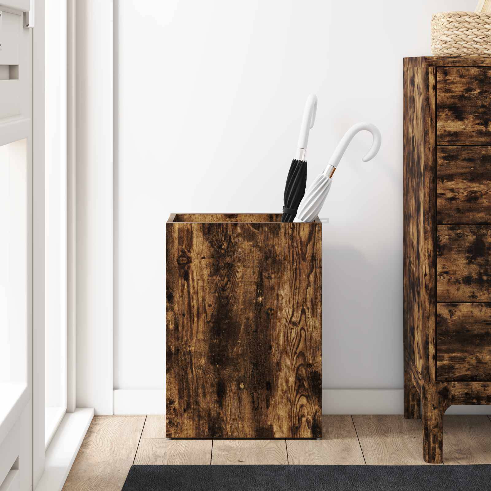 Ein hölzerner Schirmständer mit einem weiß-schwarzen Schirm steht neben einem passenden Holzschrank auf einem hellen Holzboden.