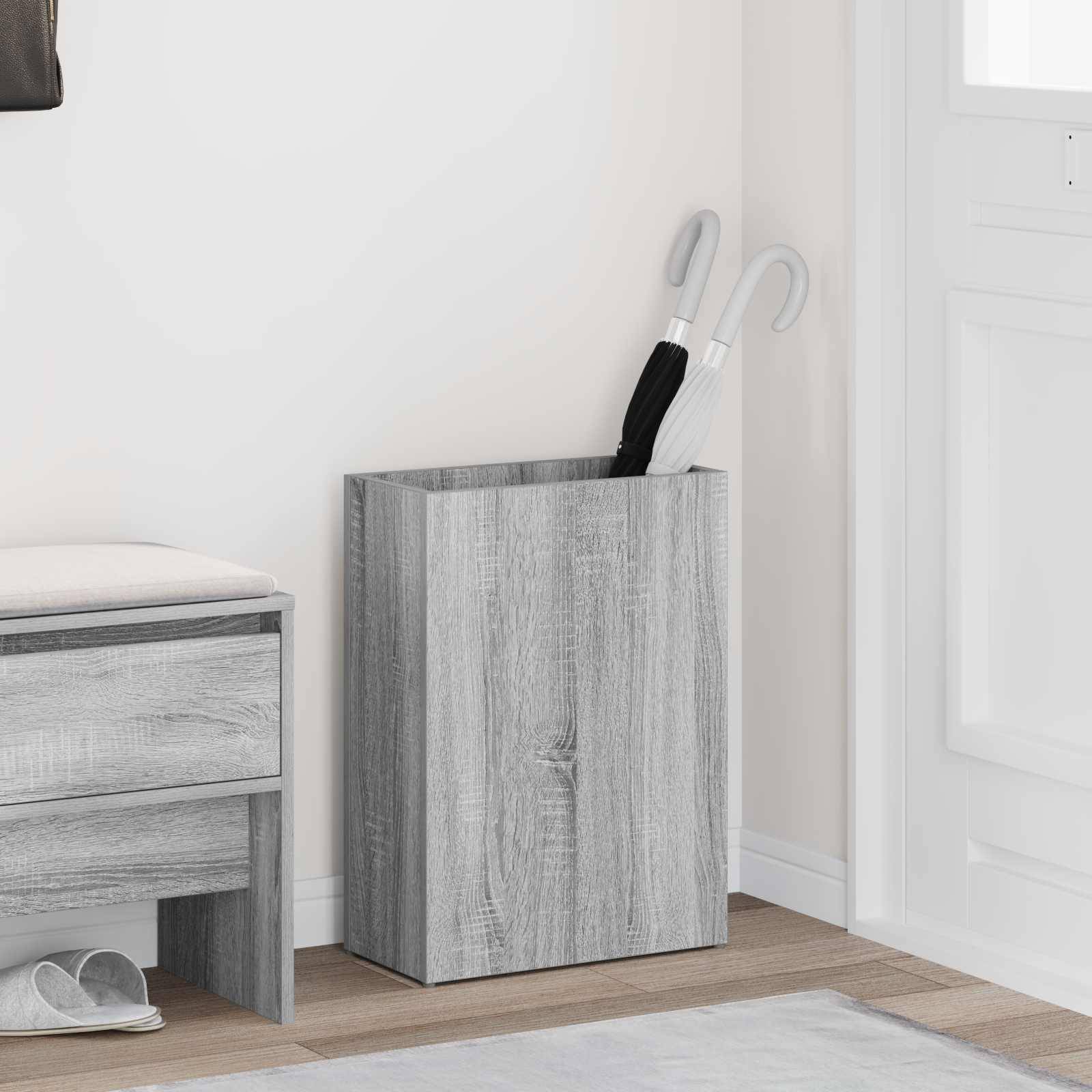 Moderner Eingangsbereich mit einer Holz-Aufbewahrungsbank, einem Schirmständer mit zwei Schirmen und einem hellgefärbten Teppich auf dem Boden.