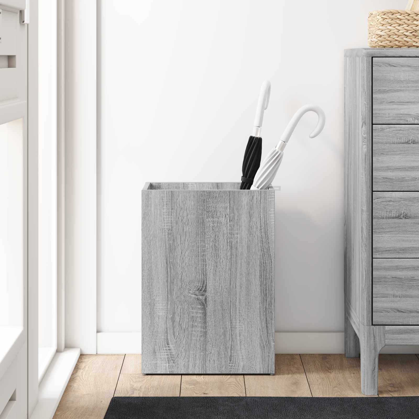 Schirmständer mit zwei Schirmen neben einer Holzkommode in einem minimalistischen Raumambiente.