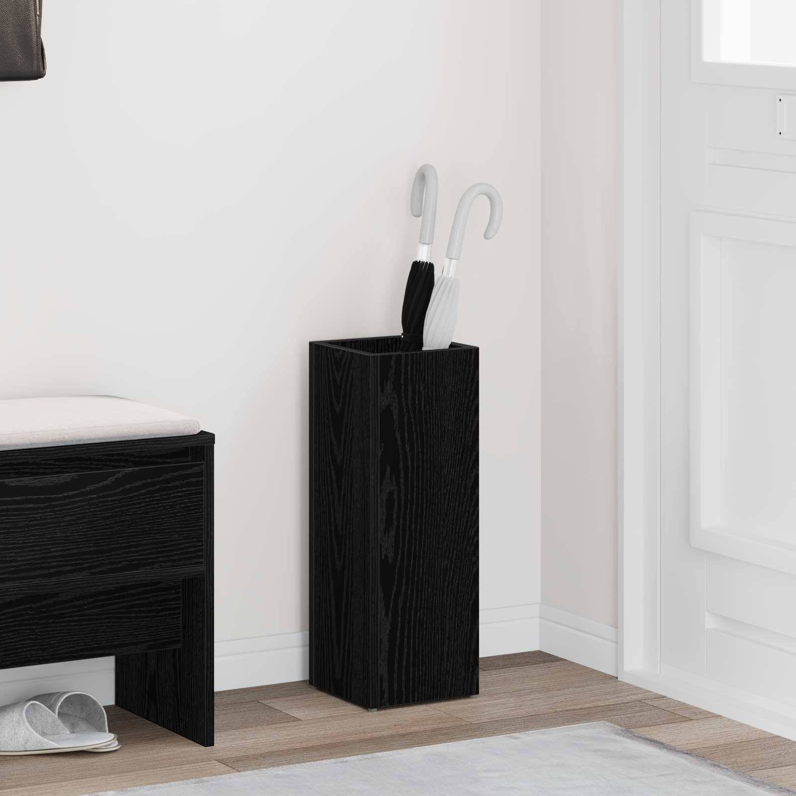 Ein minimalistischer Flur zeigt eine schwarze Holzbank und einen Schirmständer mit weißen Schirmen neben einer weißen Wand.