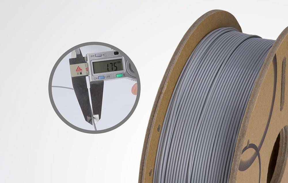 Eine Rolle grauen Filaments mit einem digitalen Messschieber links, der seinen Durchmesser mit '1,75' Millimetern anzeigt.