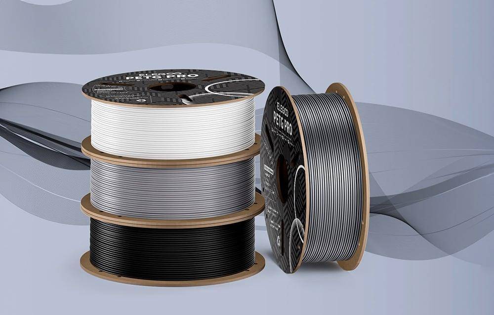 Fünf gestapelte Spulen von 3D-Druckfilament in Weiß, Grau und Schwarz, mit der Aufschrift 'Elegoo PETG PRO', vor einem neutralen Hintergrund.