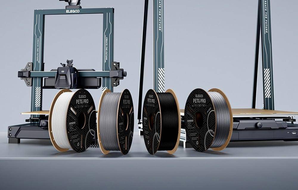 Eine 3D-Drucker-Einrichtung mit mehreren Filamentrollen von ELEGOO, die mit 'ABS', 'PETG', 'PLA' und 'PETG PRO' beschriftet sind, in verschiedenen Farben.