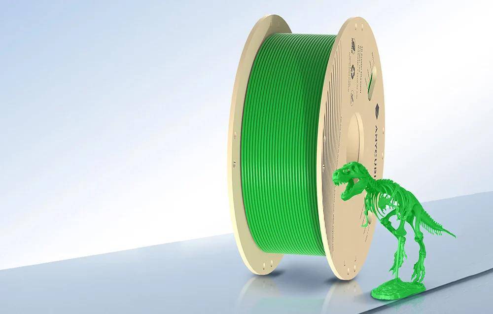 Eine Spule grünen 3D-Druckfilaments mit einem kleinen grünen Dinosauriermodell daneben.