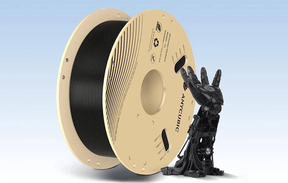 Eine große Spule schwarzen 3D-Druckfilaments steht aufrecht neben einer schwarzen Roboterhand, die nach oben zeigt, vor einem hellblauen Hintergrund.