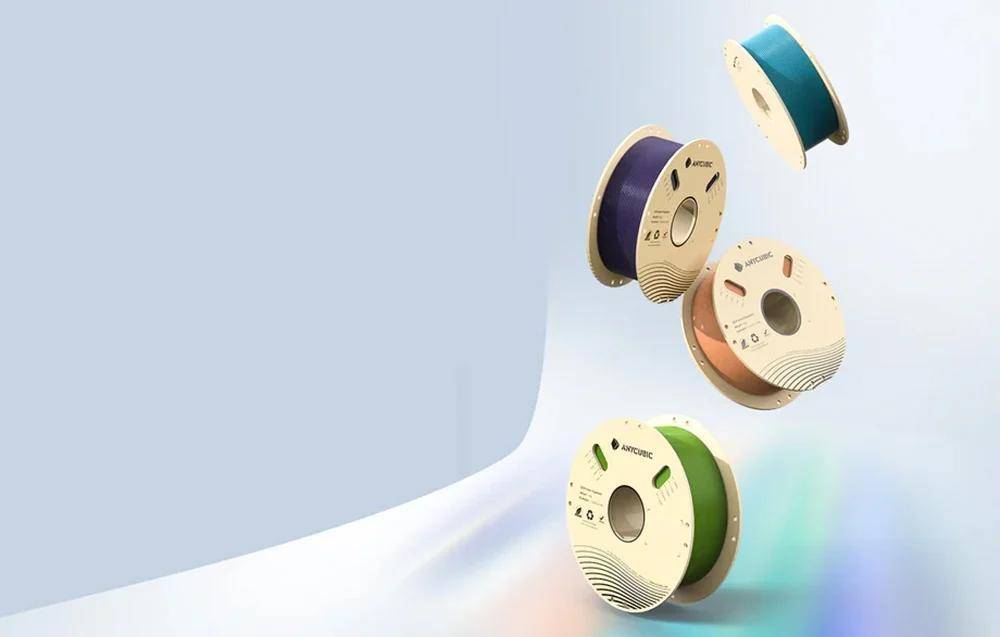 Mehrere Rollen farbiger 3D-Druckerfilamente (blau, weiß, grün, lila) in einer schwebenden Zusammenstellung angeordnet, mit sichtbaren Markenlogos.