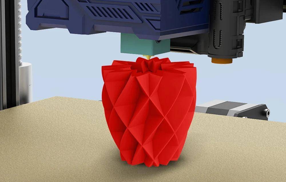 Ein 3D-Drucker, der eine rote, geometrische Vase erstellt und dabei detaillierte Schichten und Präzision im Druckprozess zeigt.
