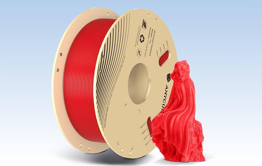 Eine große Spule roten 3D-Druckfilaments neben einem skulptierten roten Objekt, was das Potenzial des Filaments für komplexe Designs veranschaulicht.