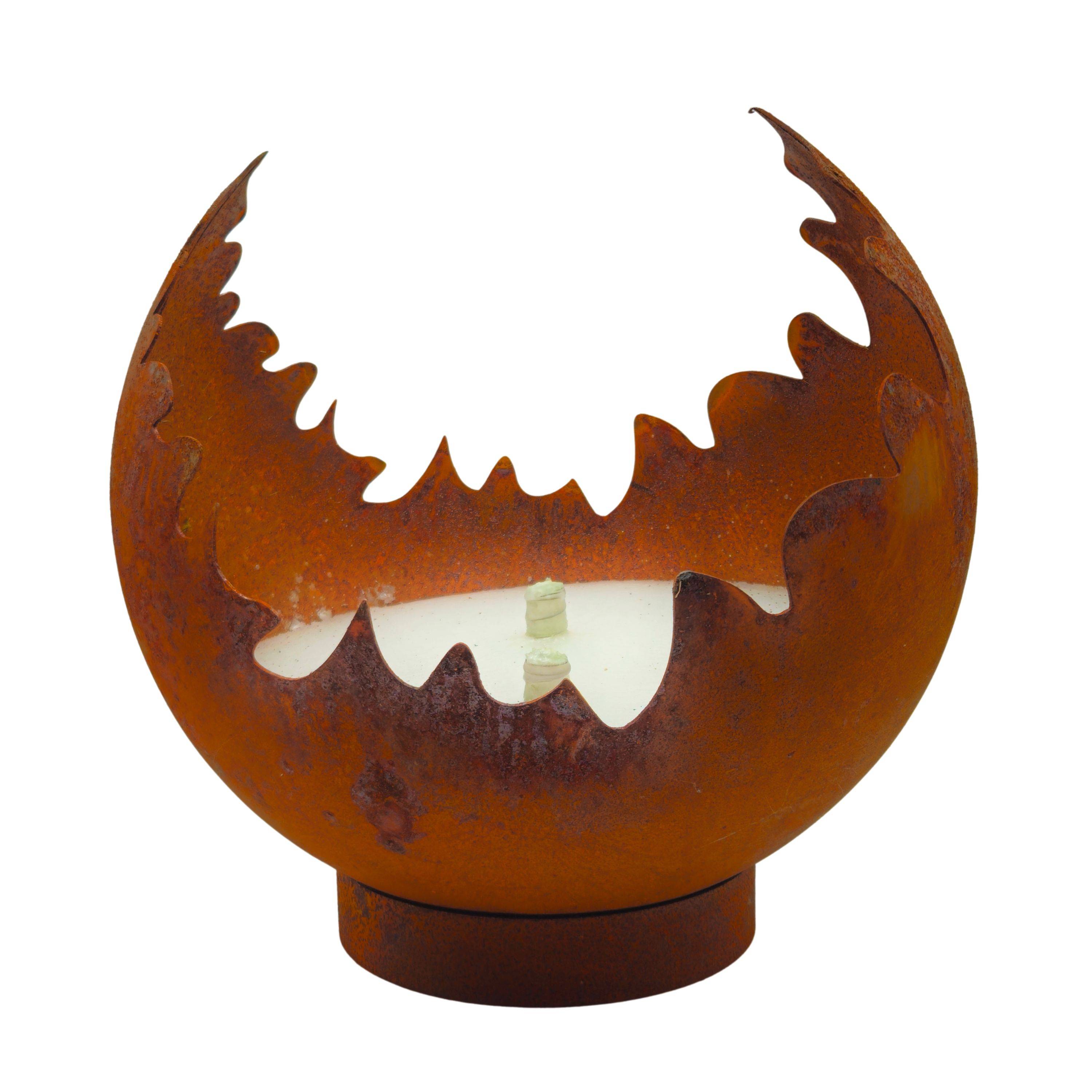 Eine verrostete Metallskulptur, die einer gesprungenen Kugel mit einer gezackten Oberseite ähnelt und auf einem Sockel ruht. Sie scheint eine Kerze oder ein Licht im Inneren zu beherbergen.