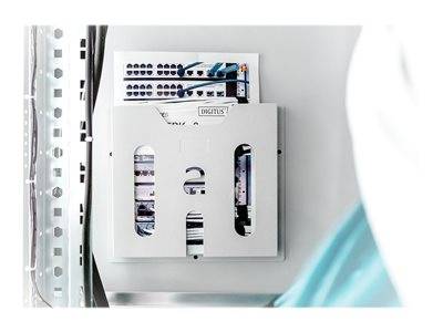 Ein technischer Zeichnungs- und Dokumentenhalter, der an einer Wand montiert ist und Papiere mit Diagrammen von Netzwerkhardware enthält.