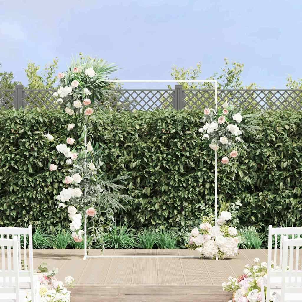 Ein Trauungsaltar im Freien mit Blumenarrangements steht vor einer grünen Hecke als Hintergrund, gerahmt von weißen Stühlen auf einem Holzdeck.