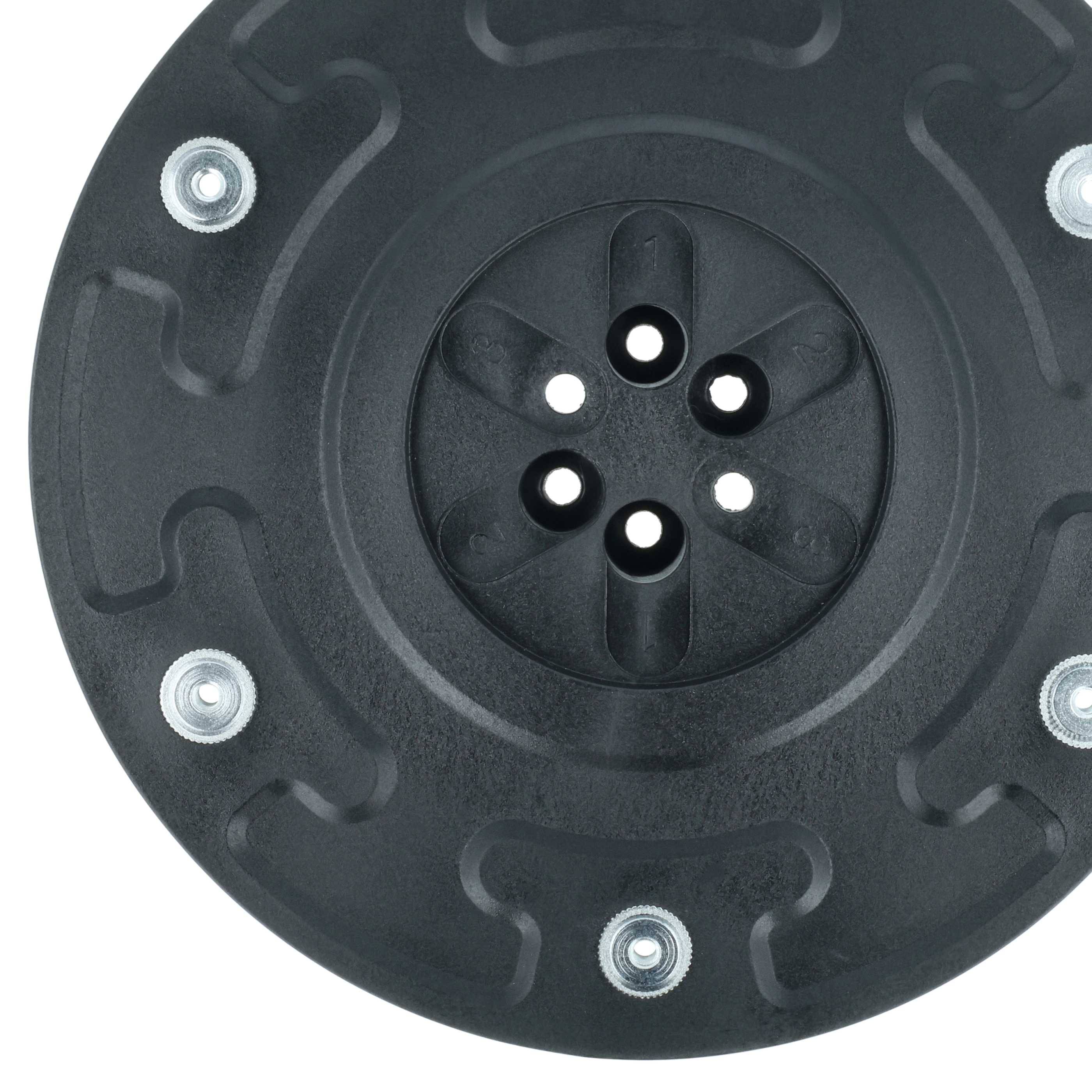 Ein schwarzer Radkranz aus Kunststoff mit einem kreisförmigen Muster und vier sichtbaren Radbolzenlöchern, umgeben von silbernen Metallschrauben.