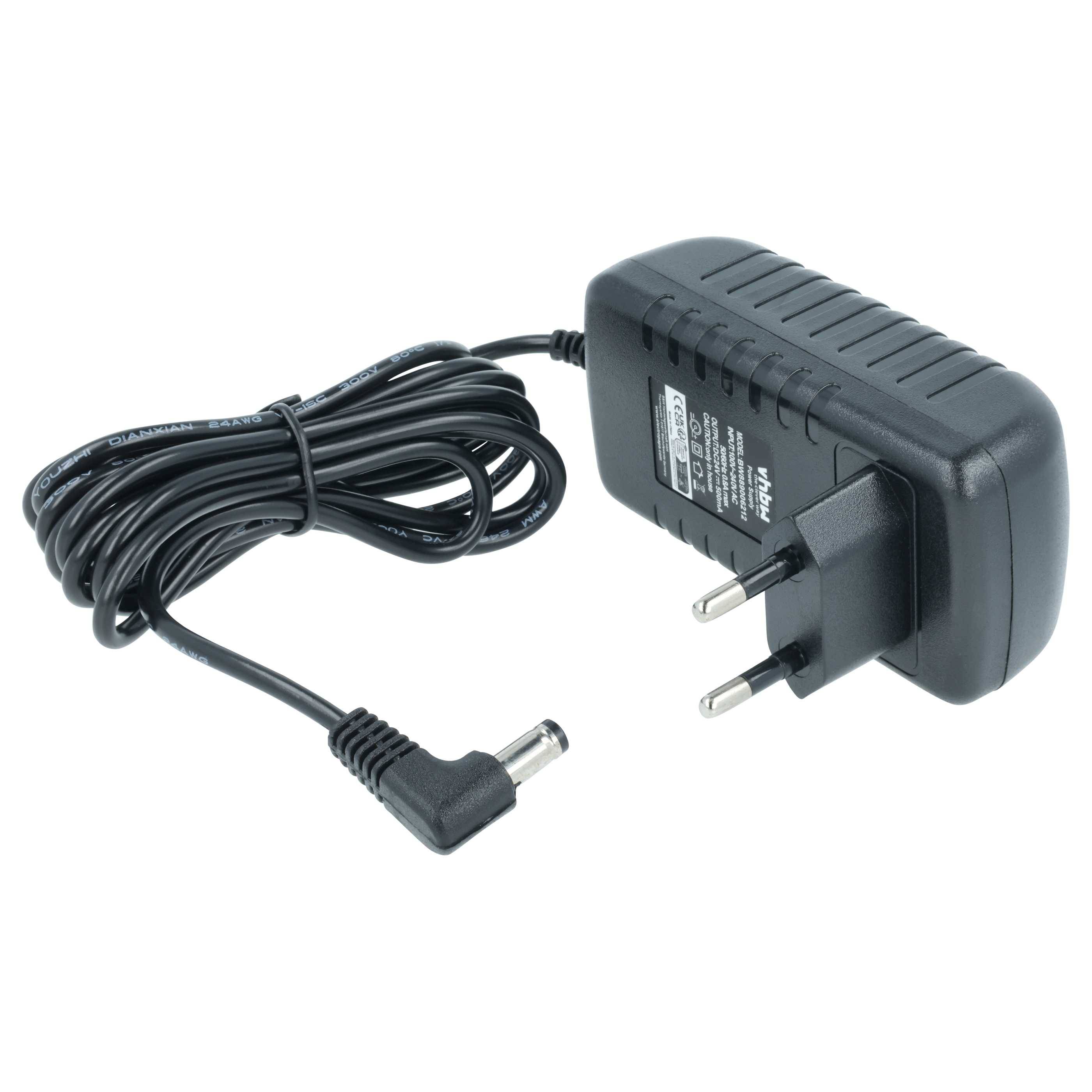 Ein schwarzes Netzteil mit zwei runden Stiften und einem langen Kabel liegt daneben sorgfältig aufgerollt. Das Netzteil hat ein Etikett mit technischen Spezifikationen.
