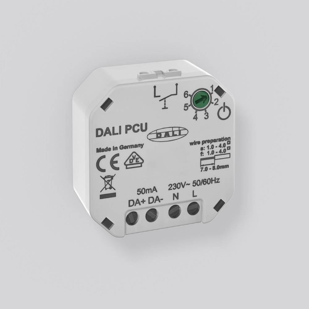 Ein kleines weißes elektronisches Gerät mit der Bezeichnung 'DALI PCU', das Anschlussports, einen grünen Knopf und technische Spezifikationen für die Verkabelung zeigt.
