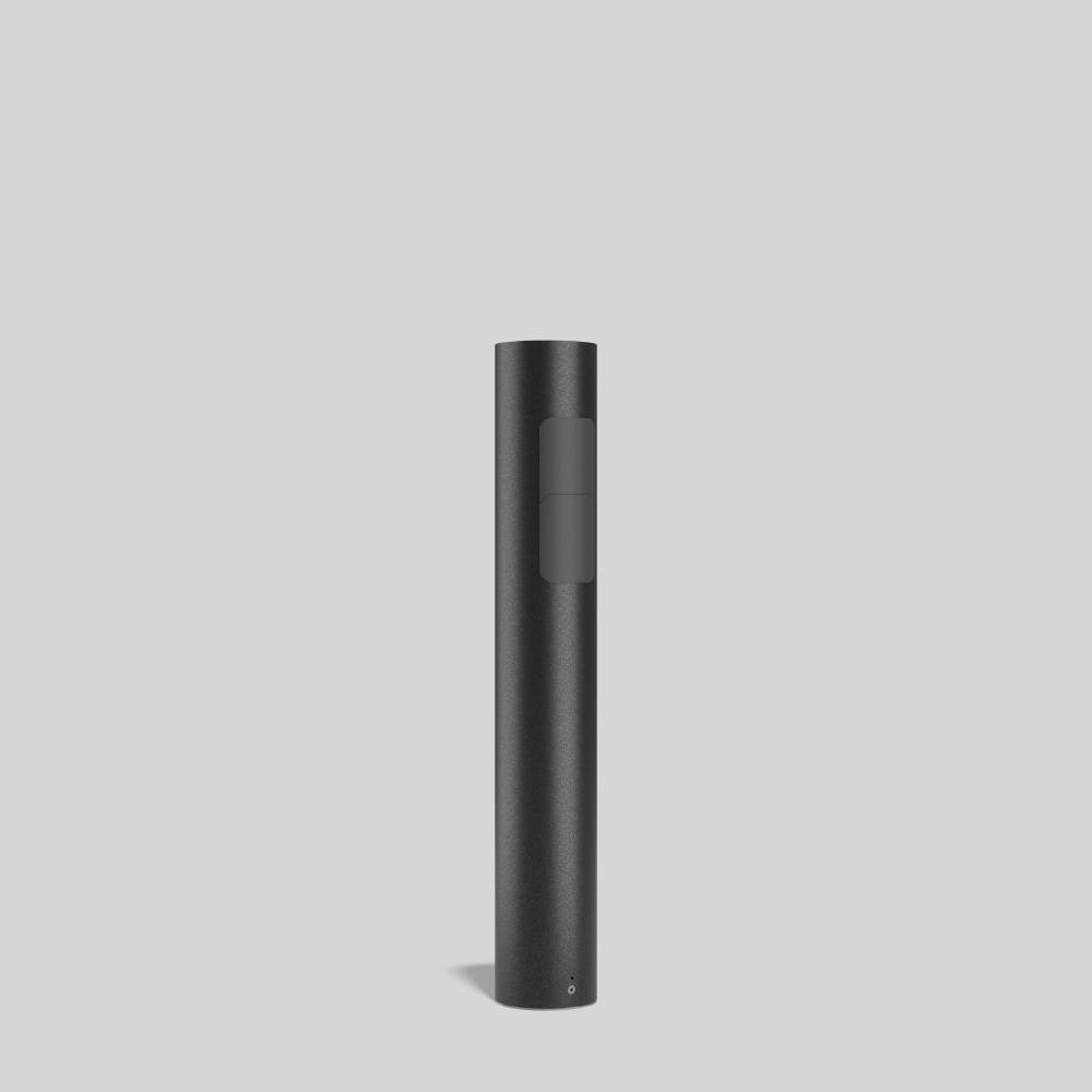 Ein schlankes schwarzes Vaping-Gerät steht aufrecht vor einem schlichten, hellgrauen Hintergrund. Das Gerät hat ein minimalistisches Design mit einem einzigen Knopf.