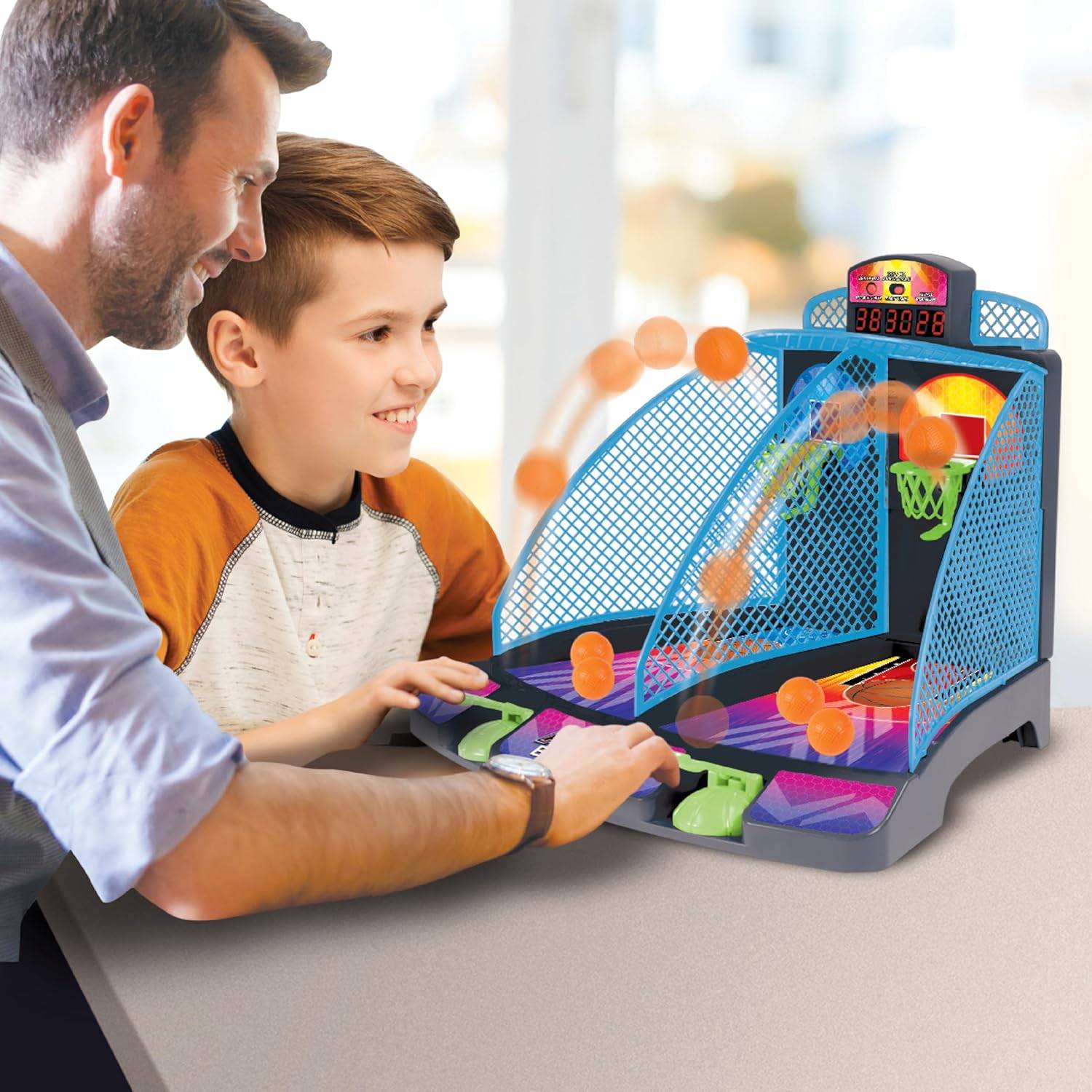 Ein Mann und ein Junge spielen ein Basketball-Arcade-Spiel auf einem Tisch und konzentrieren sich darauf, Basketbälle in die Körbe zu zielen und zu werfen.
