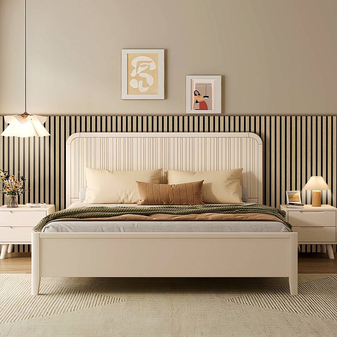 Ein stilvolles Schlafzimmer mit einem weißen Bett, einer grünen Decke, zwei Nachttischen mit Lampen und gerahmten Kunstwerken an der Wand dahinter.