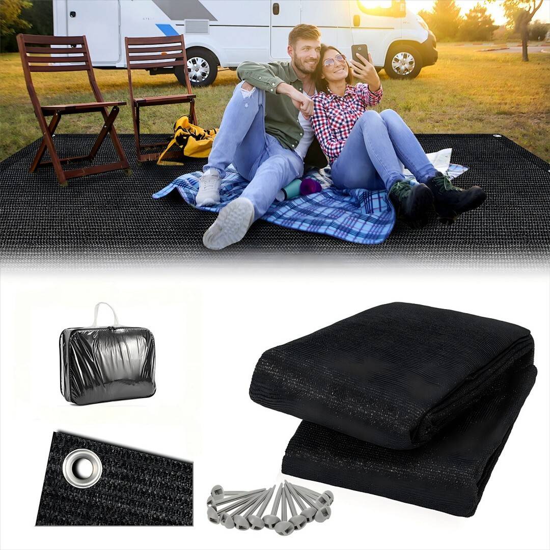 Ein Paar sitzt auf einer Picknickdecke vor einem Wohnmobil. In ihrer Nähe stehen zwei Stühle und eine Matte, darunter sind eine Tasche und Heringe zu sehen.