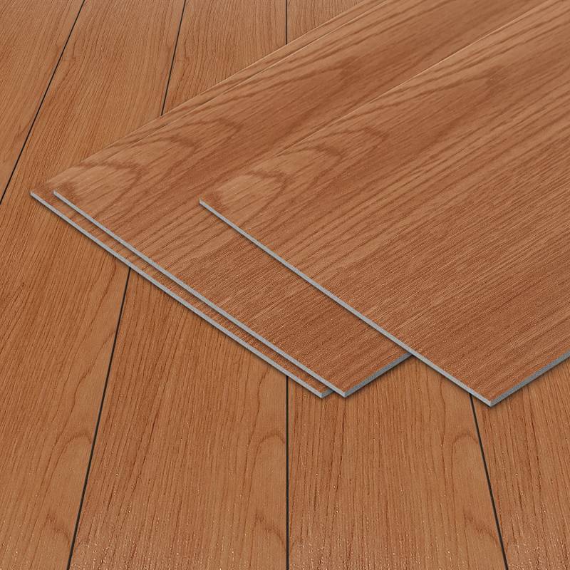 Drei Laminatbodenplatten in Holzoptik, die auf einem Holzboden ausgerichtet sind und eine natürliche Holzmaserung sowie eine warme braune Farbe präsentieren.