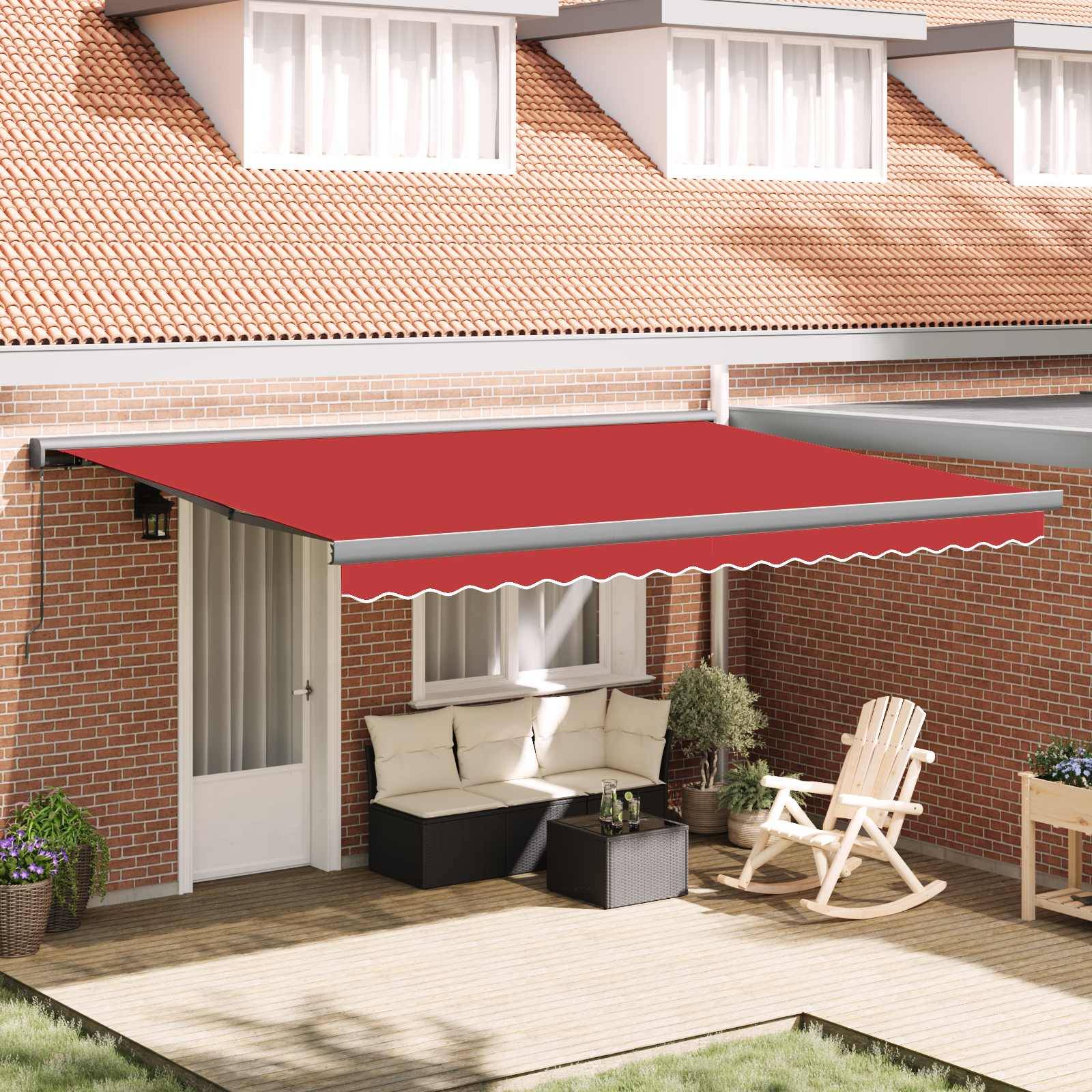 Eine rote ausziehbare Markise erstreckt sich über eine Terrassentür und sorgt für Schatten über Außensitzgelegenheiten mit einem kleinen Tisch und Pflanzen, angebracht an einem Backsteinhaus.