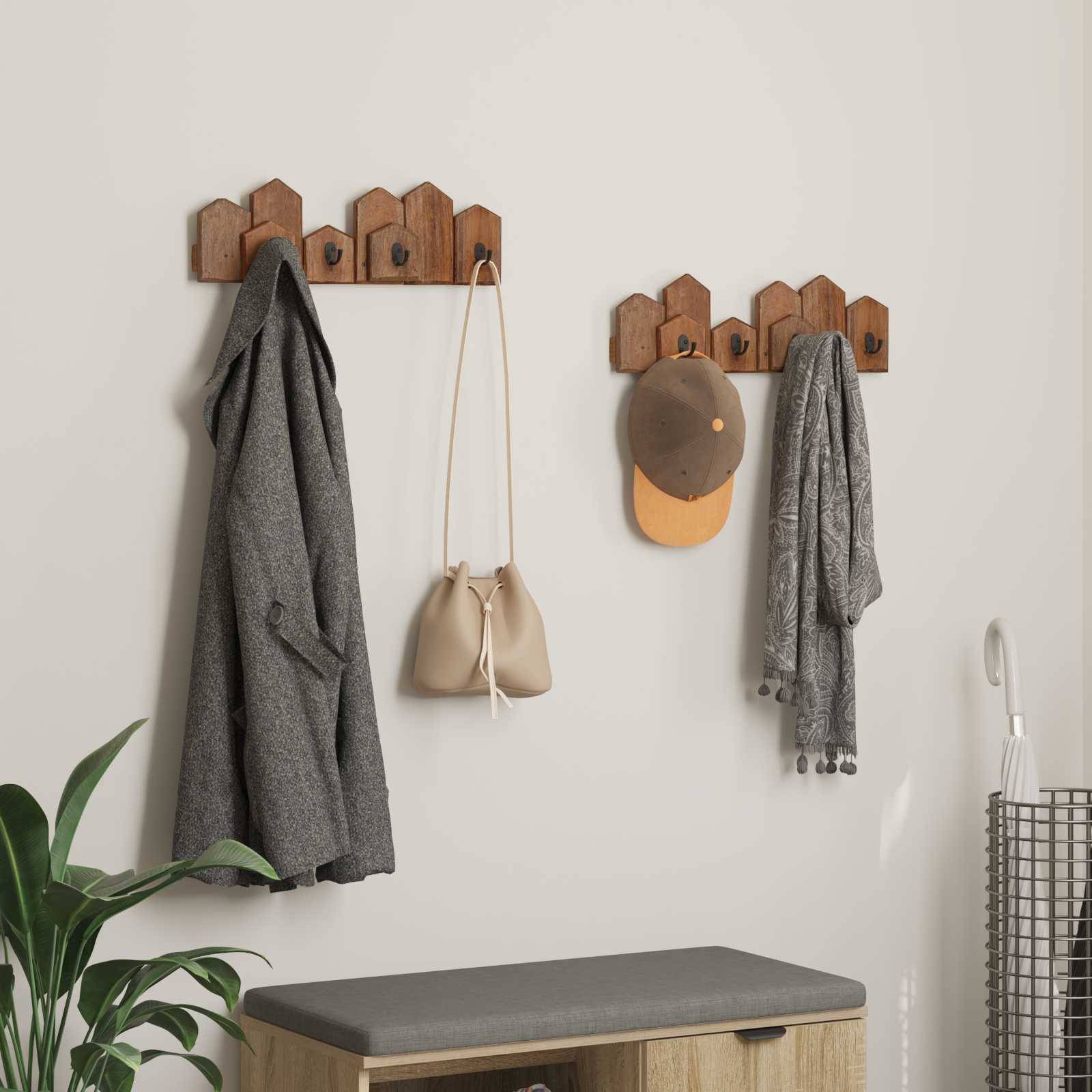 An der Wand befestigter Garderobenständer mit braunen Haken, an denen eine graue Jacke, eine beige Tasche, ein brauner Hut und ein grauer Schal hängen. Darunter eine kleine Holzbank.