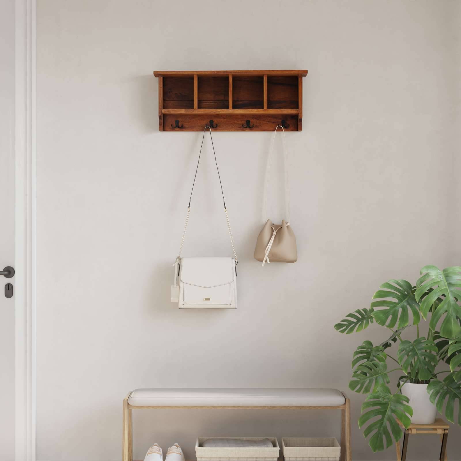 Eine minimalistische Diele zeigt ein Holzwandregal mit Haken, an denen zwei Handtaschen hängen, eine schliche Bank und eine Zierpflanze als Dekoration.