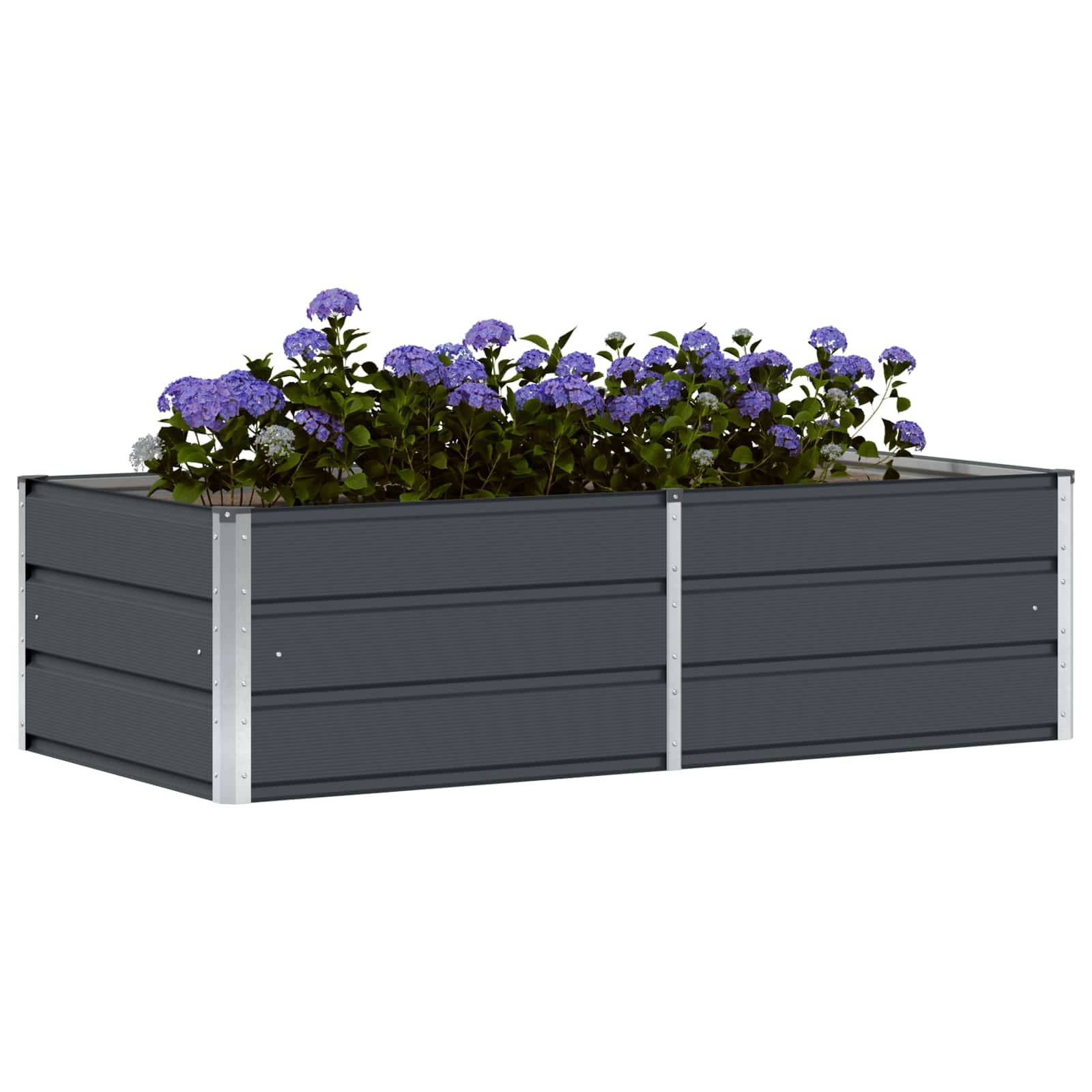 Ein grauer, rechteckiger erhöhter Gartenbeet, gefüllt mit grünen Pflanzen und violetten Blumen.