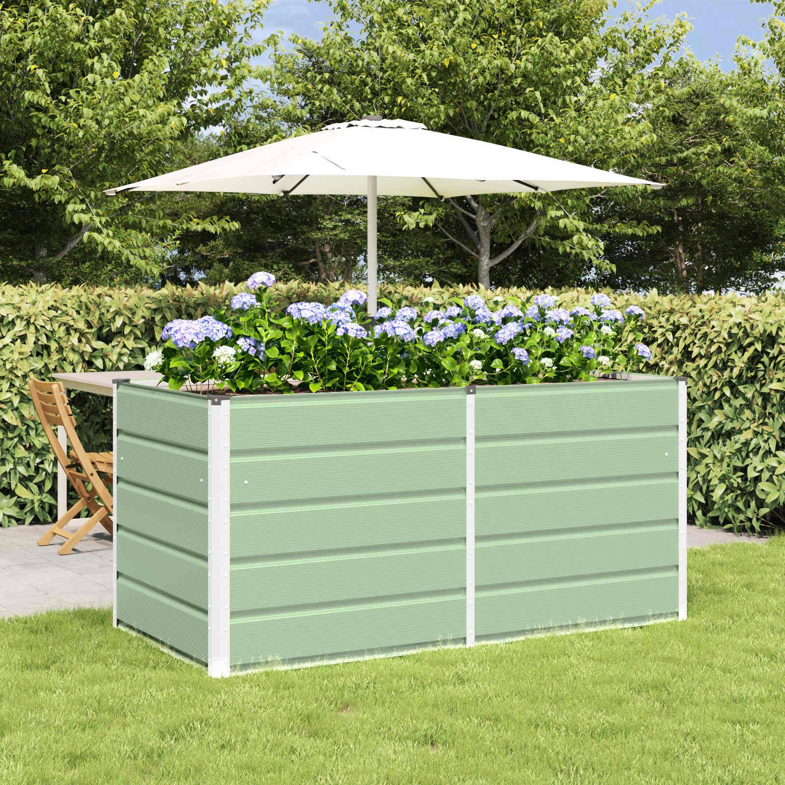 Ein erhöhtes Hochbeet mit blühenden blauen Blumen steht auf einem Rasen. Ein großer weißer Sonnenschirm spendet Schatten. Tische und Stühle befinden sich in der Nähe.