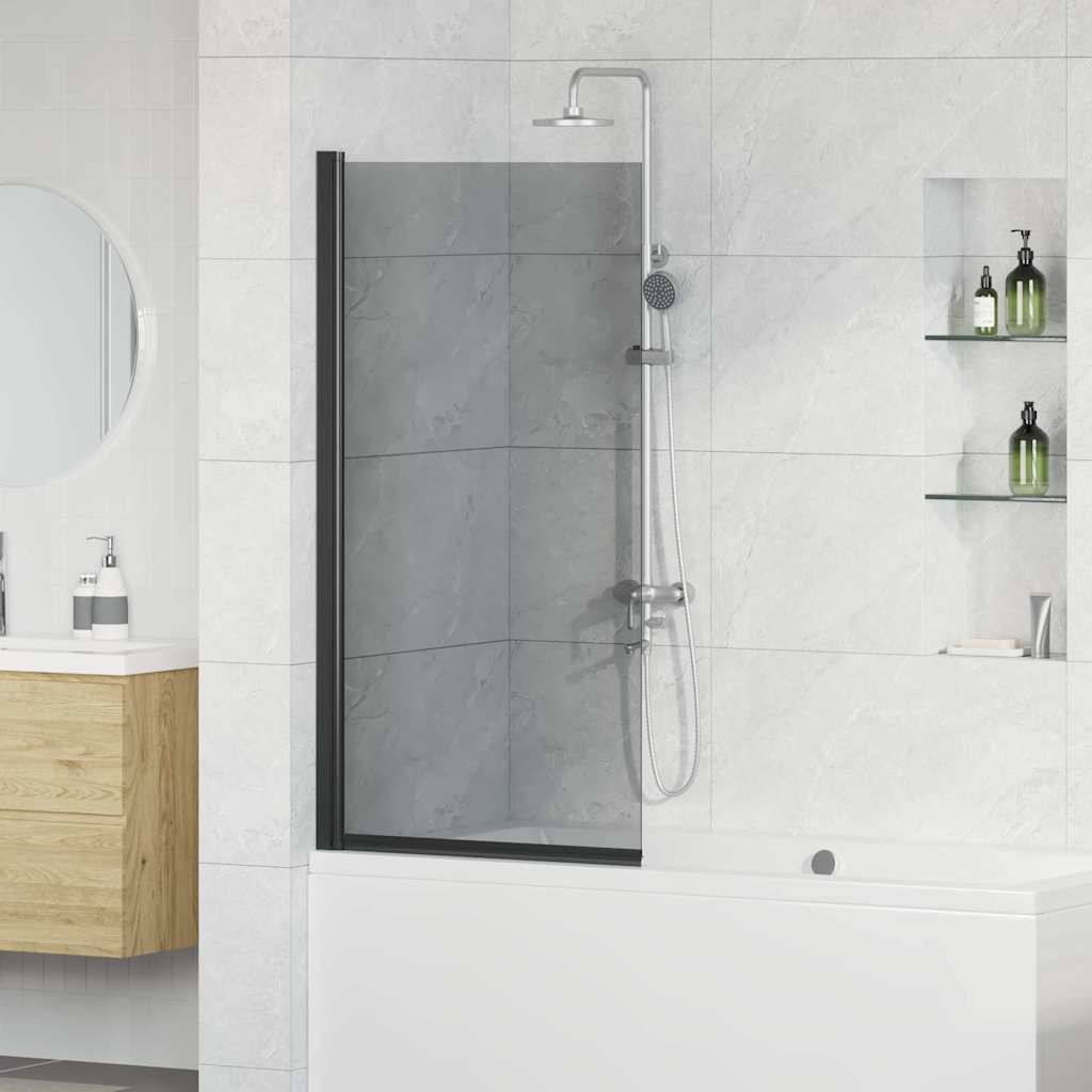 Ein modernes Badezimmer mit einer Dusche mit Glastür, hellgrauen Fliesen, einem runden Spiegel, einem Holzwaschtisch und Wandregalen, auf denen grüne Flaschen stehen.