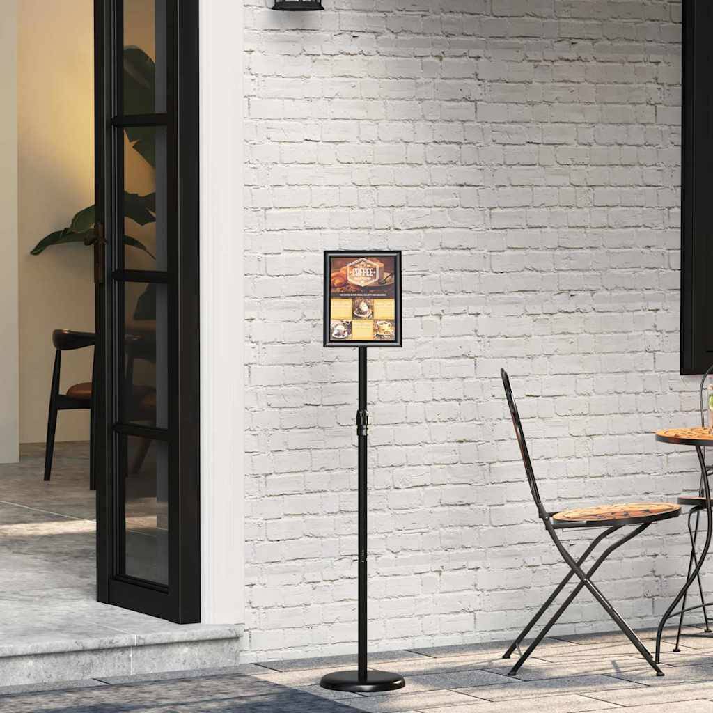 Ein kleiner Tisch- und Stuhlset auf einer Ziegelsteinterrasse, mit einer offenen Tür, die zu einem Innenraum führt. Ein Schild mit Bildern steht auf einem Pfahl.