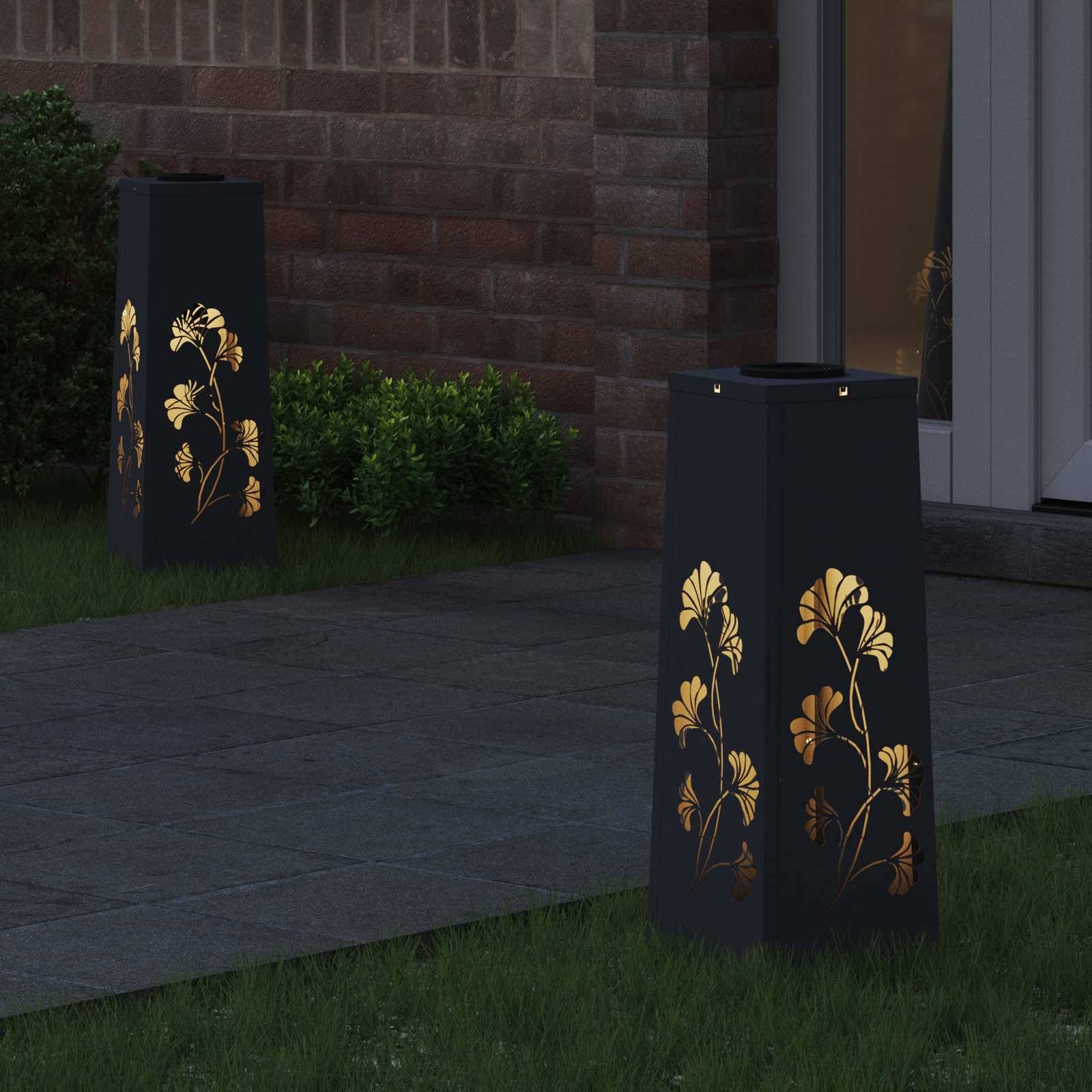 Gartenlaternen mit Blumenausschnitten beleuchten einen gepflasterten Weg, der von Gras und Sträuchern gesäumt wird.