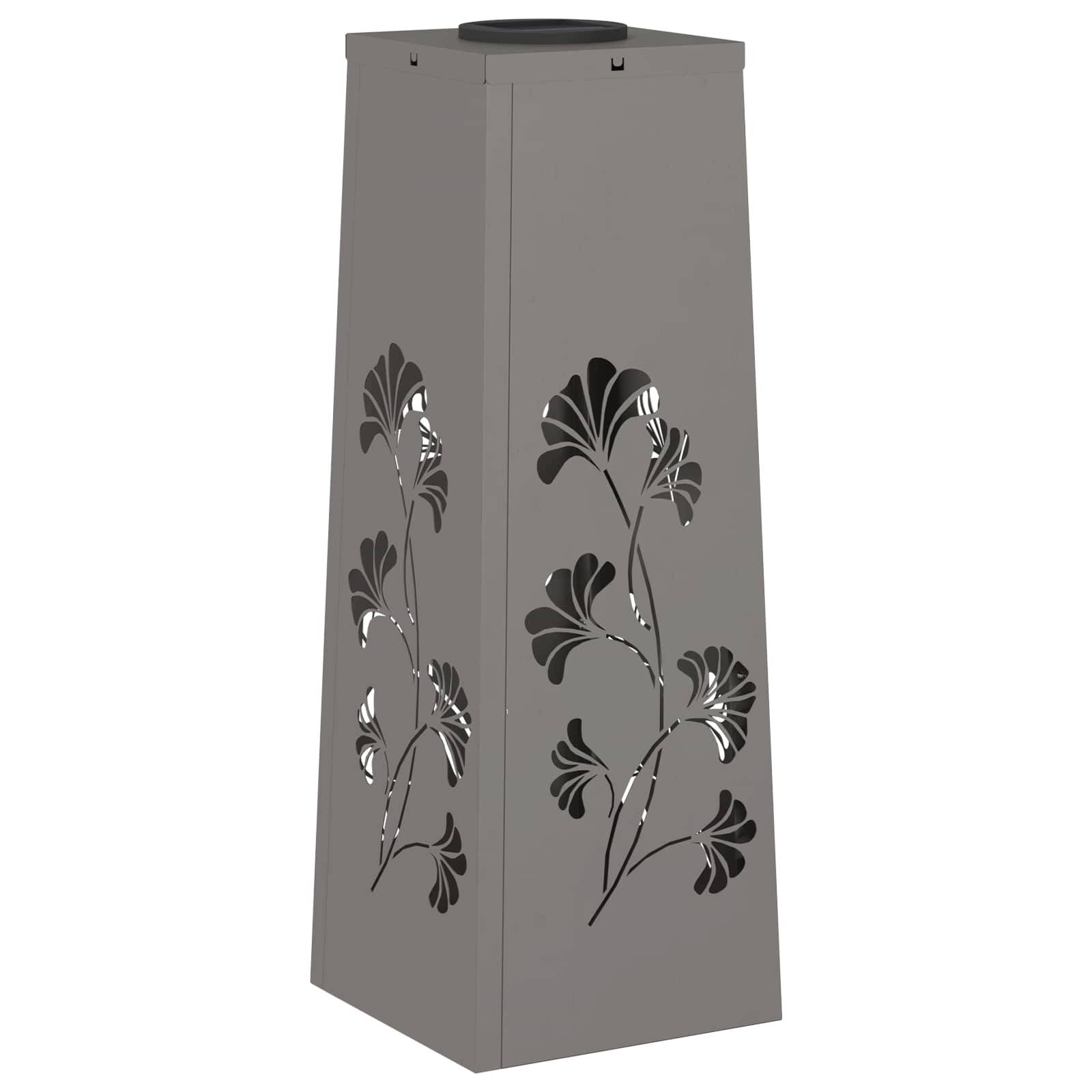 Eine hohe, graue, trapezförmige Laterne mit Blumenschnittmuster auf den Seiten, das Licht durchscheinen lässt.