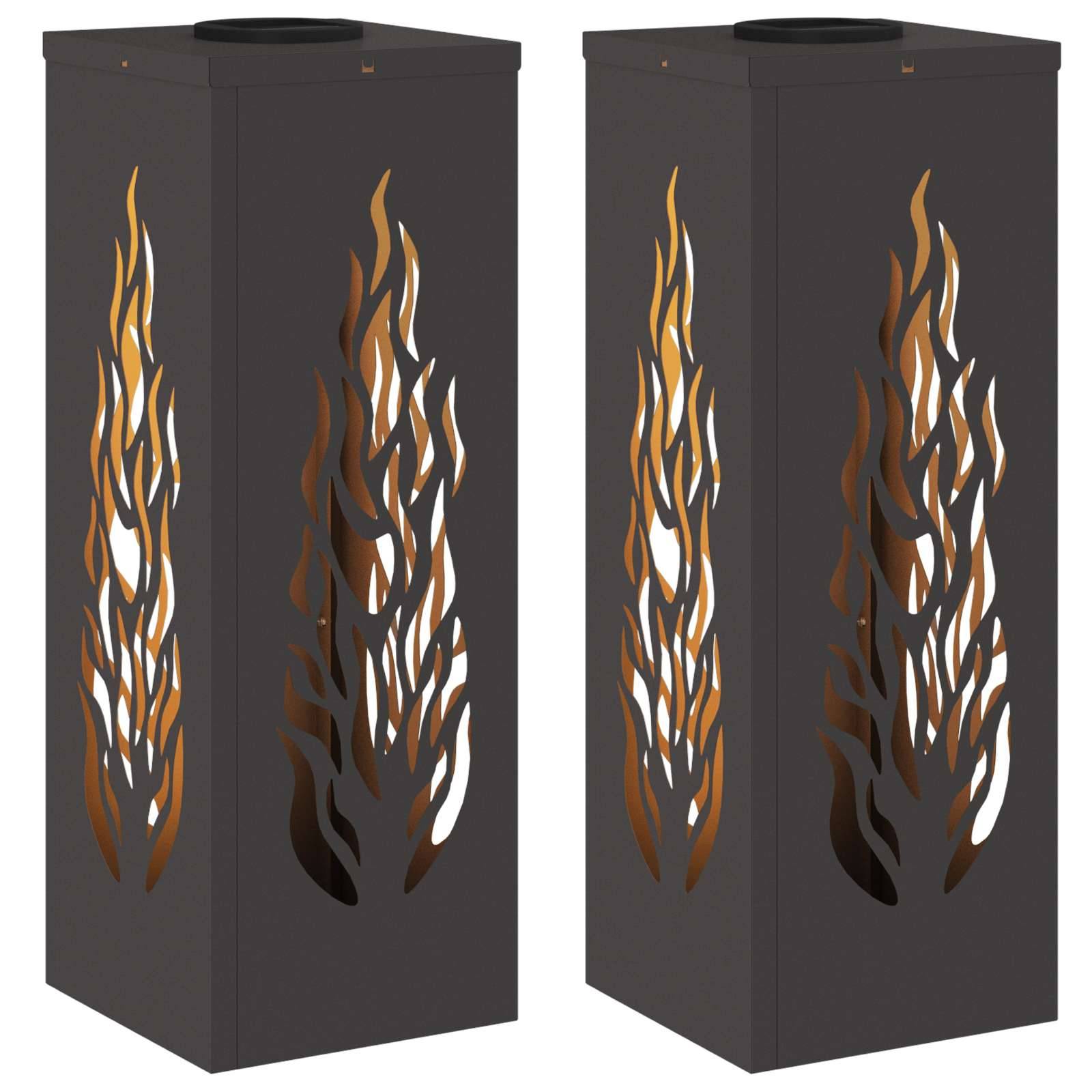 Zwei hohe, rechteckige schwarze Metalllaternen mit flammenförmigen Ausschnitten, die ein inneres Licht freilegen und einen warmen, feuerartigen Glanz hervorrufen.