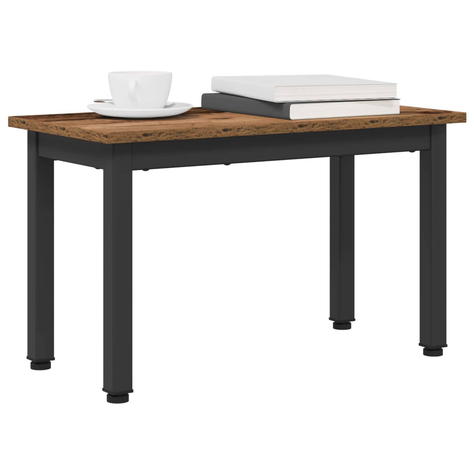 Ein kleiner Holz-Couchtisch mit schwarzen Beinen, auf dessen Oberfläche eine weiße Kaffeetasse und zwei übereinander gestapelte Bücher liegen.