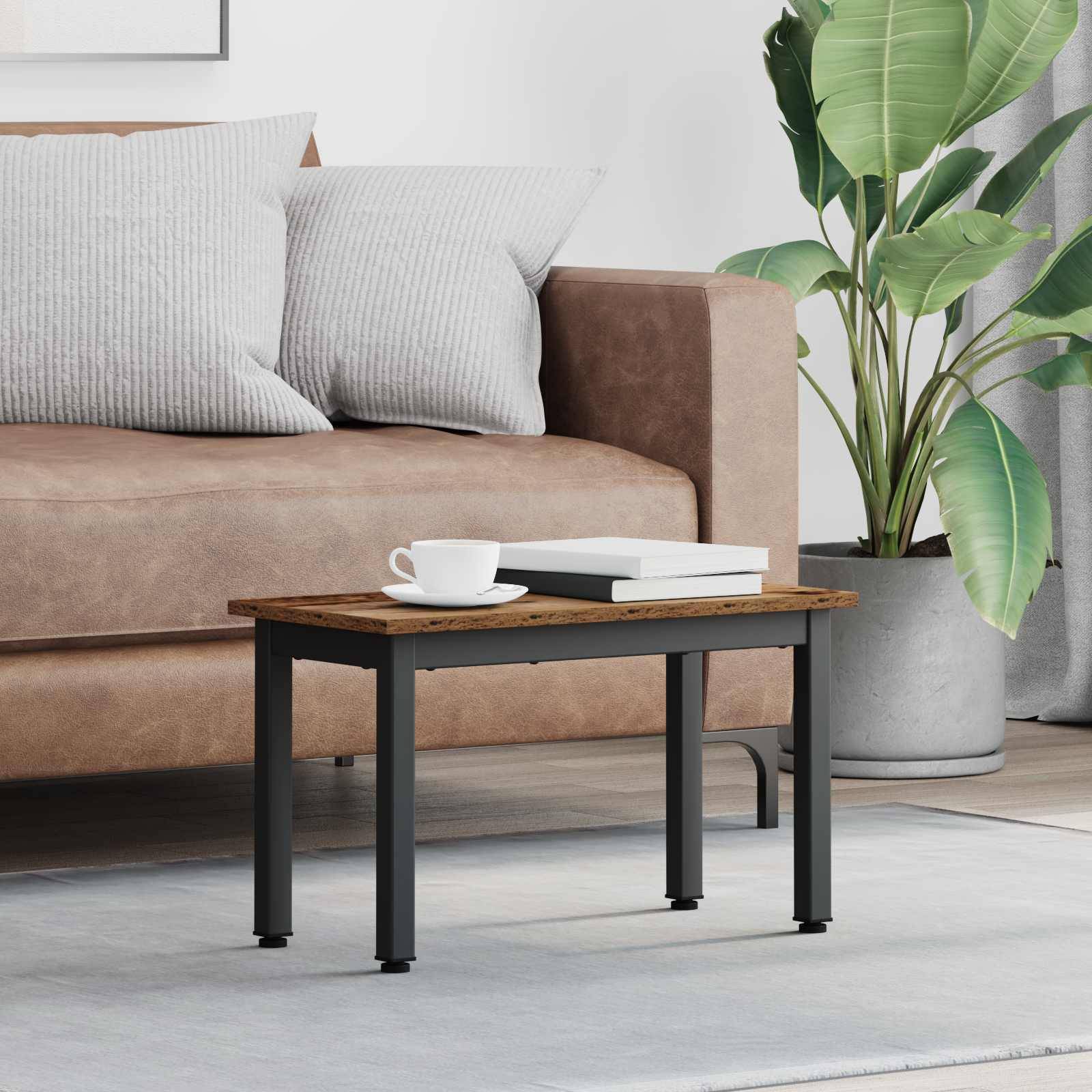 Ein modernes Wohnzimmer mit einem braunen Sofa, geschmückt mit gestreiften grauen Kissen, einem kleinen rechteckigen Couchtisch und einer grünen Topfpflanze in der Nähe.