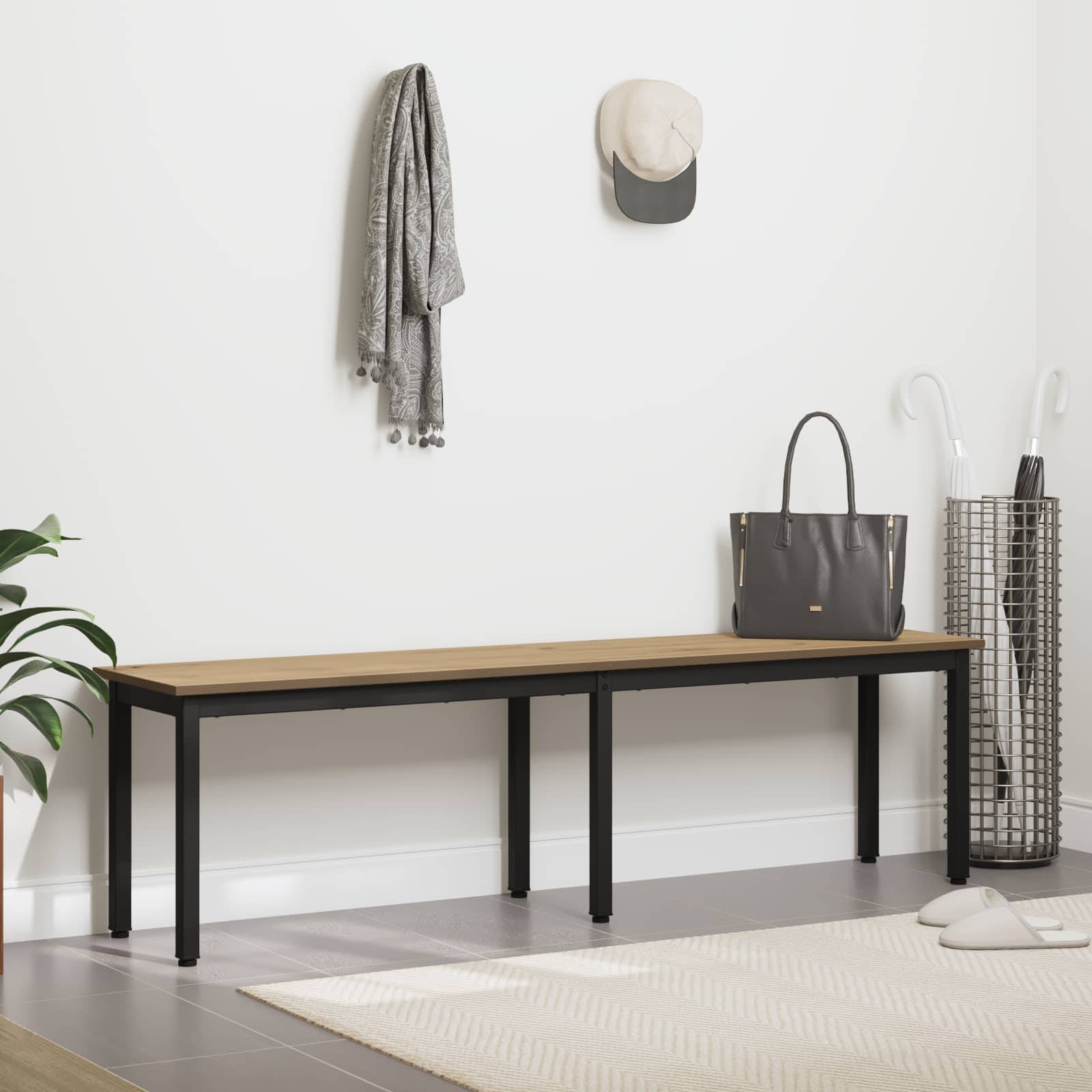 Eine minimalistische Diele mit einer Holzbank, einer Jacke und einer Mütze, die an der Wand hängen. Ein Drahtkorb steht auf dem Boden.