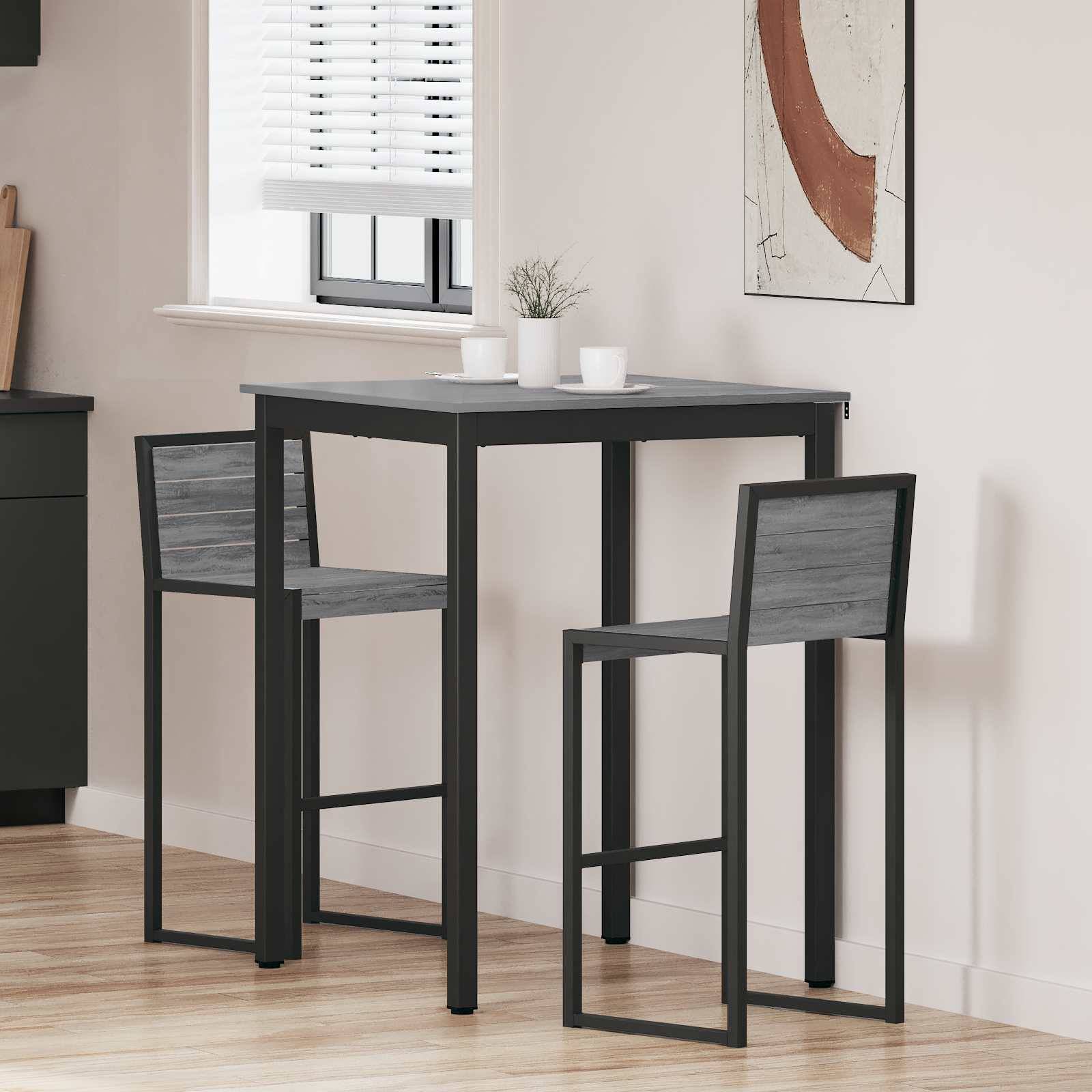 Ein moderner Essbereich zeigt einen hohen Tisch mit zwei Hockern. Auf dem Tisch stehen zwei weiße Tassen. Ein Fenster mit Jalousien und abstrakte Wandkunst befinden sich im Hintergrund.