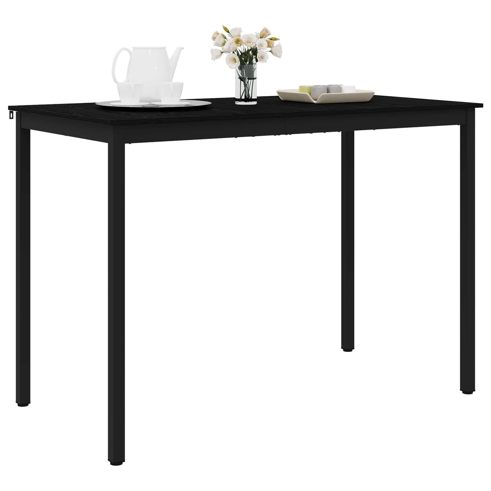 Ein schwarzer rechteckiger Tisch mit einer Vase mit Blumen, einer weißen Teekanne, Tassen auf einem Tablett und einem Stapel Bücher.