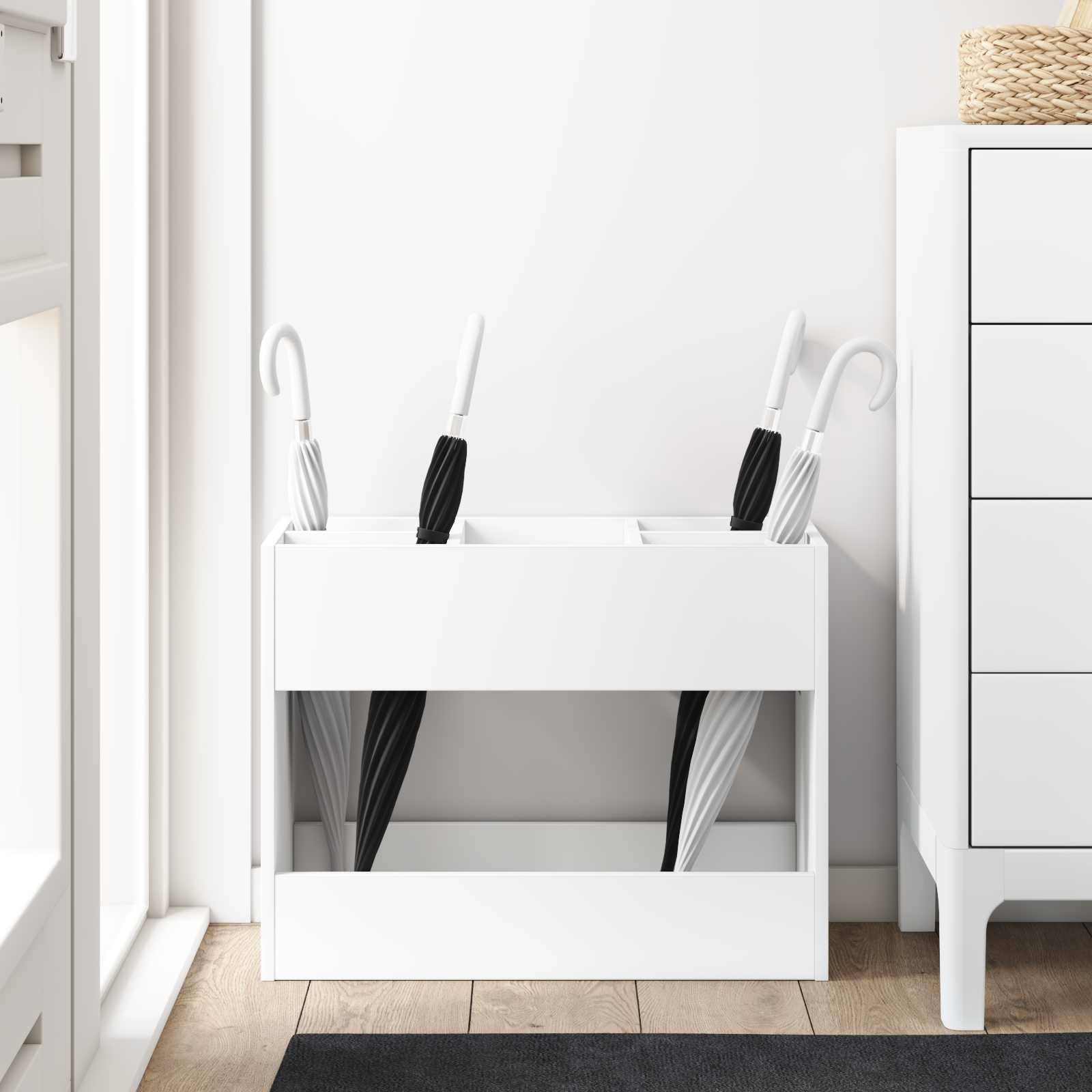 Ein weißer Schirmständer, der zwei gestreifte und zwei einfarbig schwarze Schirme neben einem weißen Schrank mit einem geflochtenen Korb auf der Oberseite enthält.