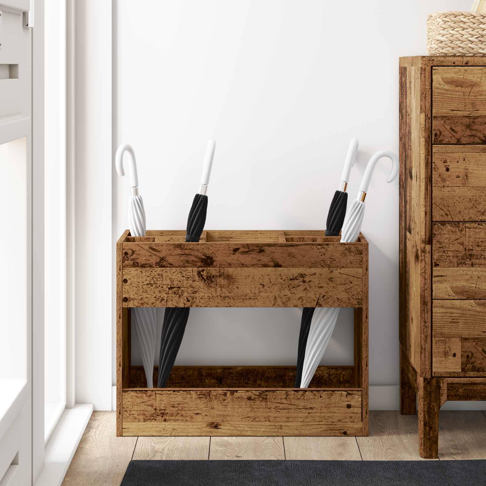 Ein hölzerner Schirmständer in einem Flur enthält mehrere schwarze und weiße Schirme. Ein rustikaler Holzschrank steht daneben.