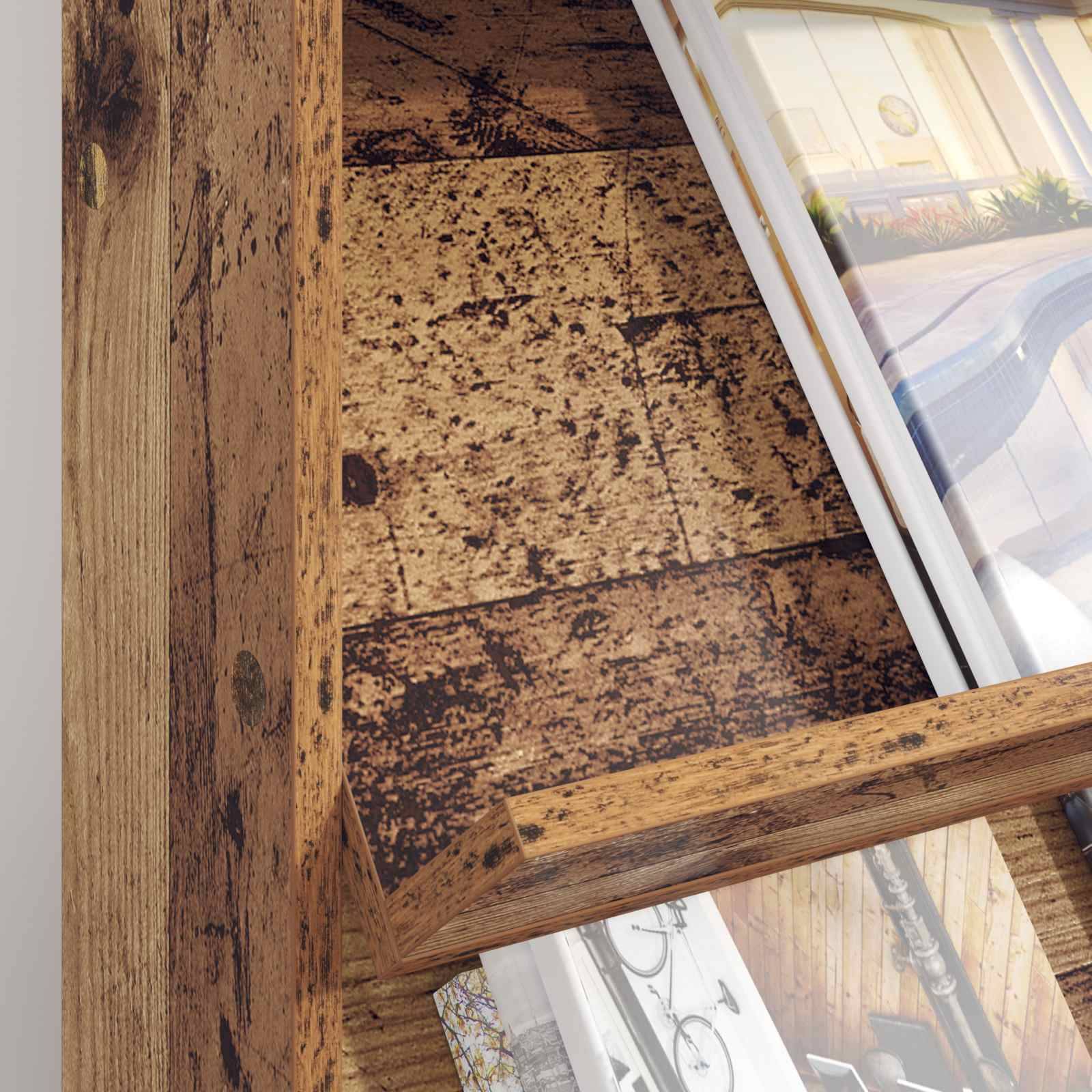 Eine Ecke eines Holzregals zeigt mehrere schräg gestellte Rahmen mit verschwommener Kunst und Fotografien, die eine rustikale Ästhetik betonen.