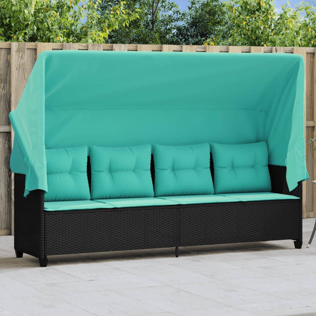 Outdoor-Rattansofa mit türkisfarbenen Kissen und Baldachin. Vor einem Holzzaun mit grünen Bäumen im Hintergrund.