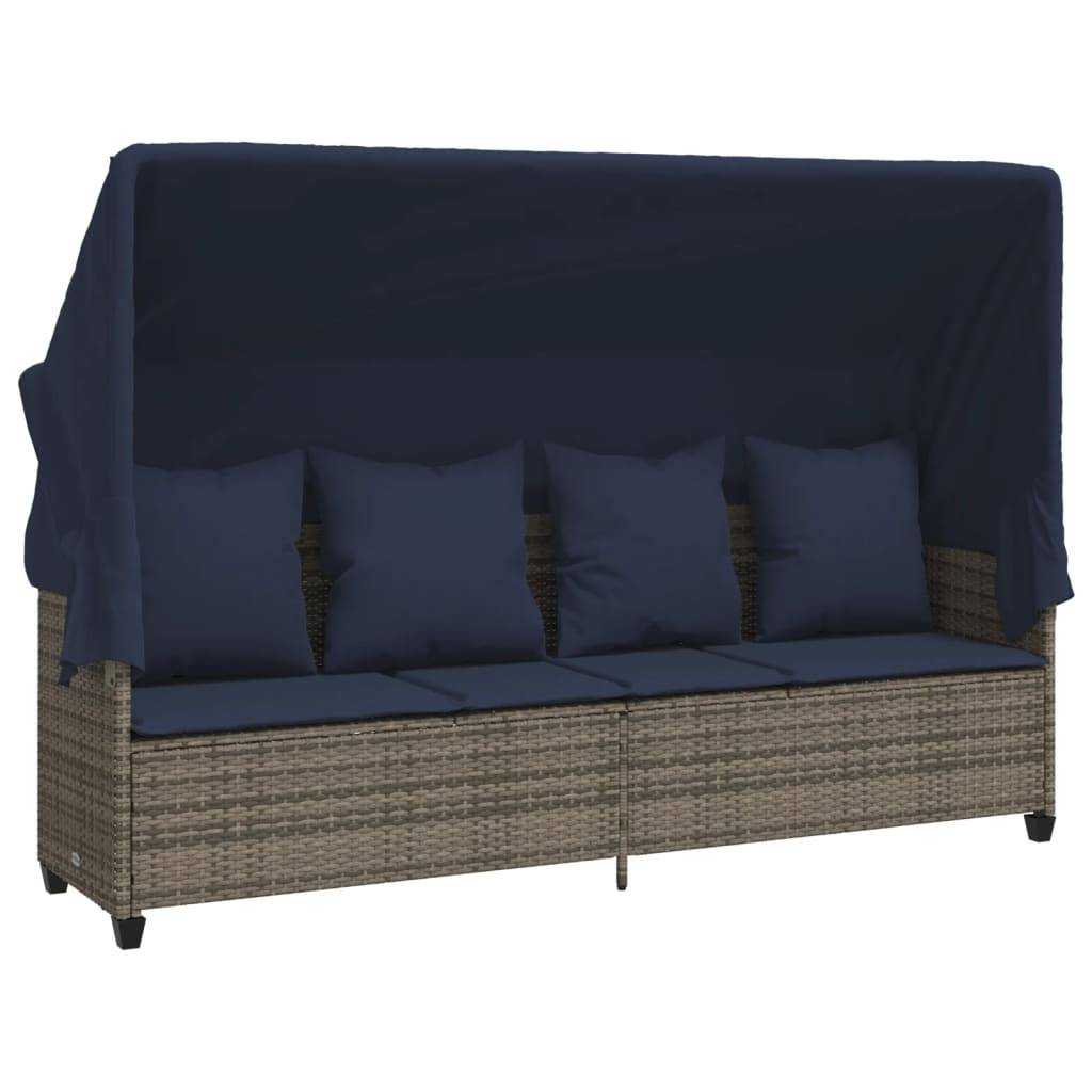 Ein Outdoor-Tagesbett aus Geflecht mit ausziehbarem Sonnendach und marineblau-farbenen Kissen, konzipiert für Entspannung und Muße in einem Garten oder auf einer Terrasse.