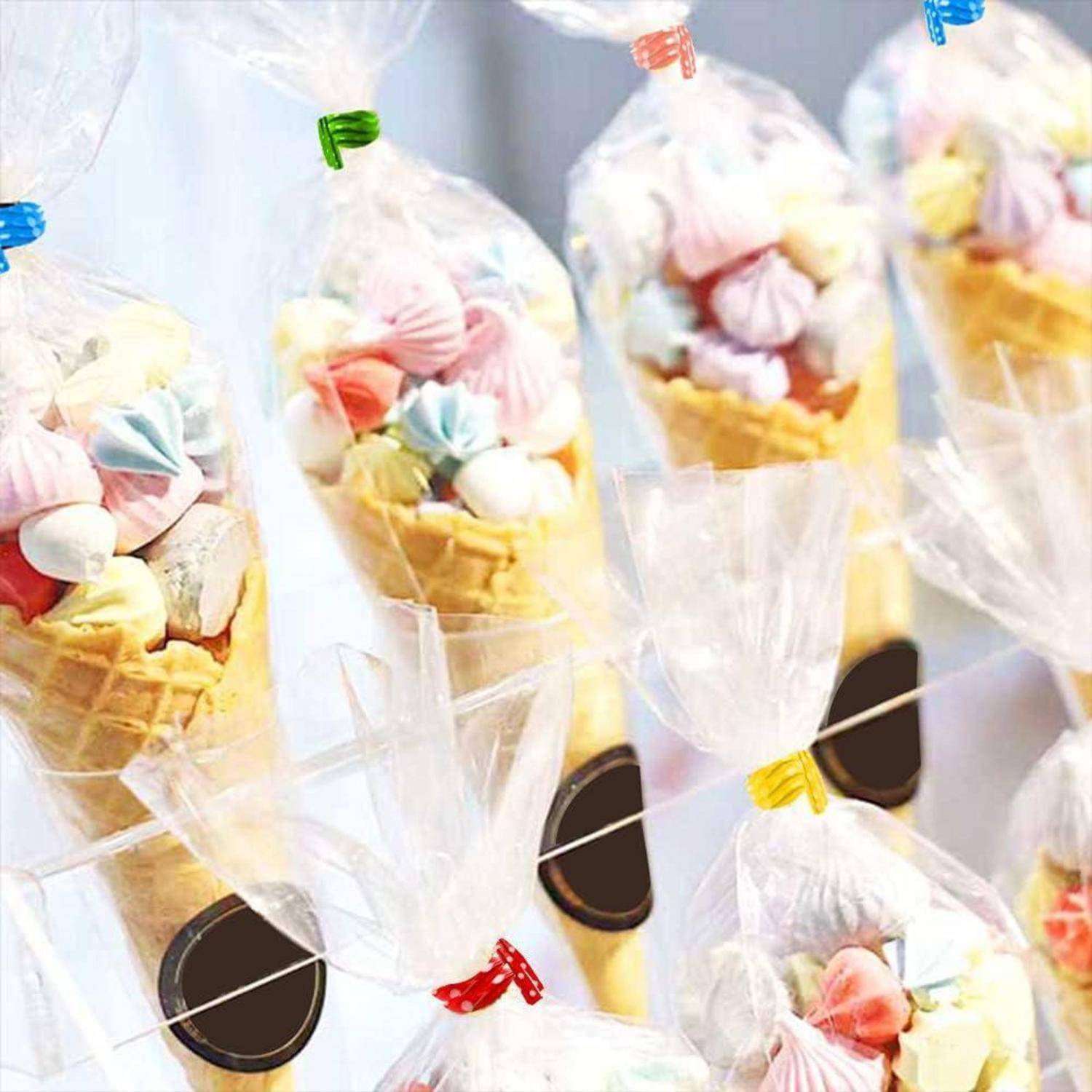 Bunte Baiser in durchsichtigen Tüten, serviert in Waffelhörnchen, jedes mit einer bunten Schleife gebunden.