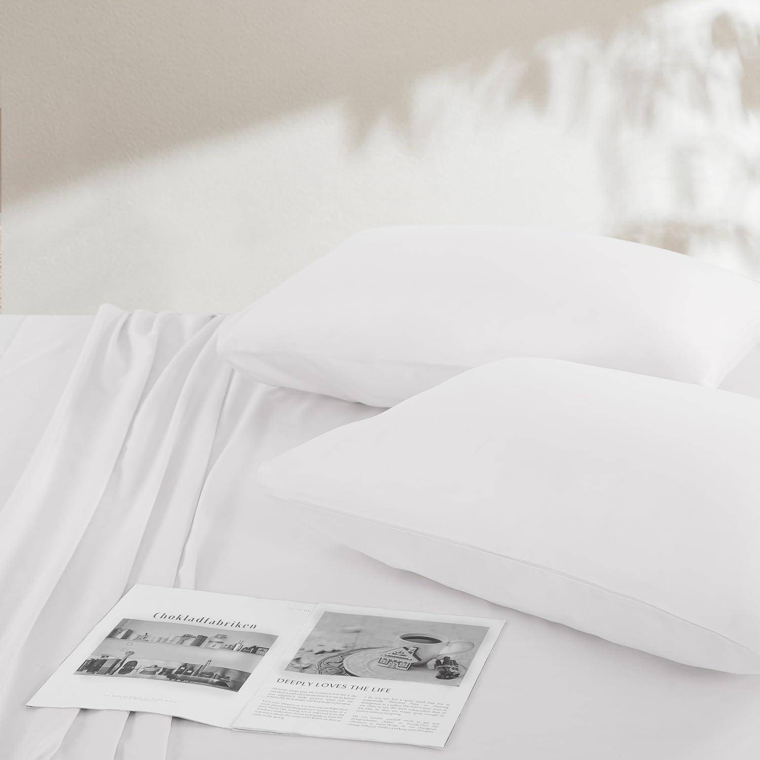 Ein ordentlich gemachtes Bett mit weißen Laken und zwei weißen Kissen. Eine aufgeschlagene Zeitschrift mit Bildern und Text liegt auf dem Bett.